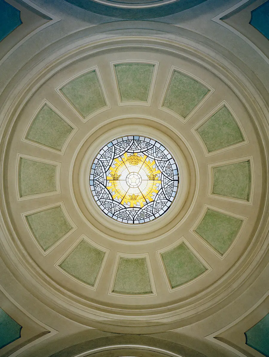 Takkupolen sedd underifrån med ett runt mosaikfönster i mitten.