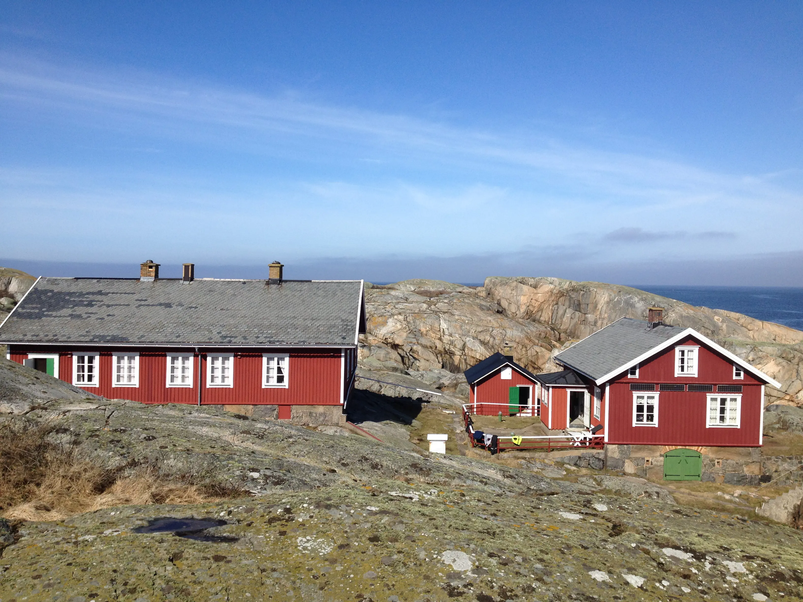 Bostadshus på Väderöbod. Två röd-målade trähus på klipporrna.