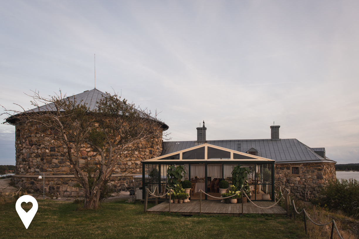 Dalarö Skans sett från sidan med växthus i förgrunden och skansen bakom