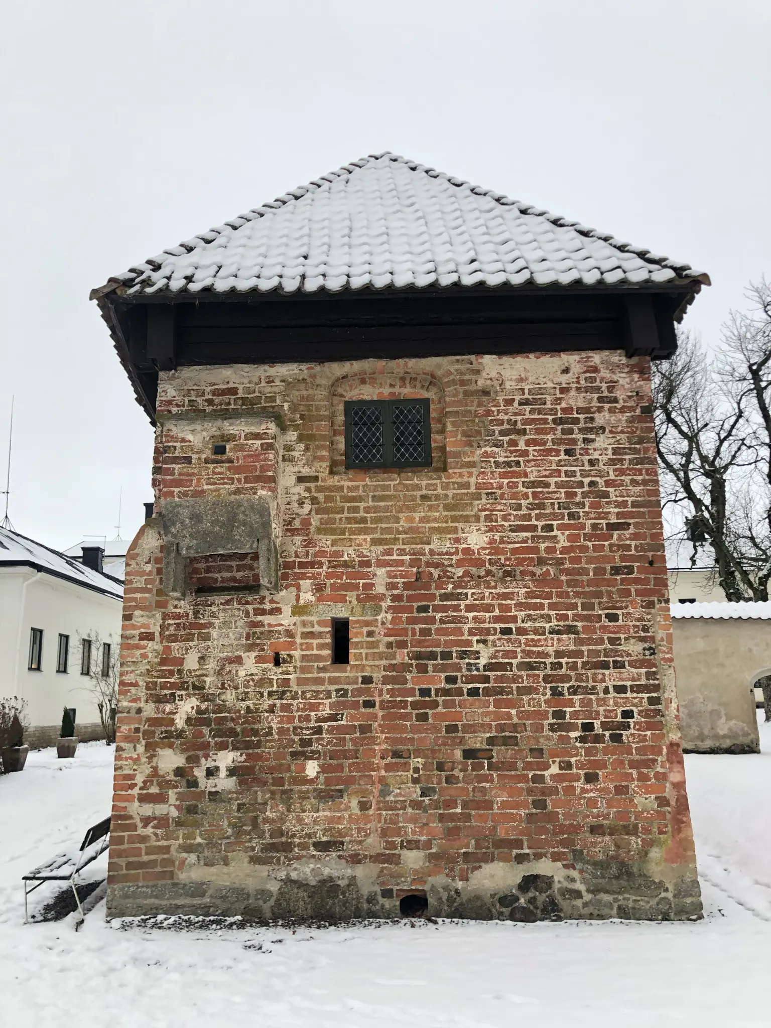 Mårten Skinnares hus, Vadstena. Liten tvåvåningsbyggnad i tegel. På gaveln hänger en liten utbyggnad för dasset. Vinter och snö.