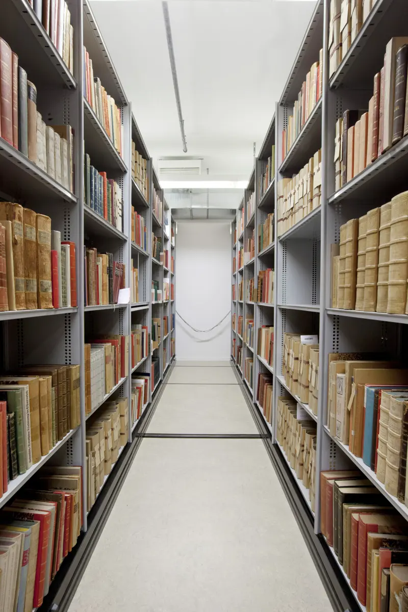 Äldre böcker på enkla metallhyllor.