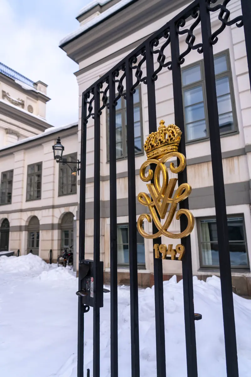 Bondeska palatset. Gjutjärns-grind med förgyllt kungligt monogram och årtalet nittonhundrafyrtionio. Vinter och snö.