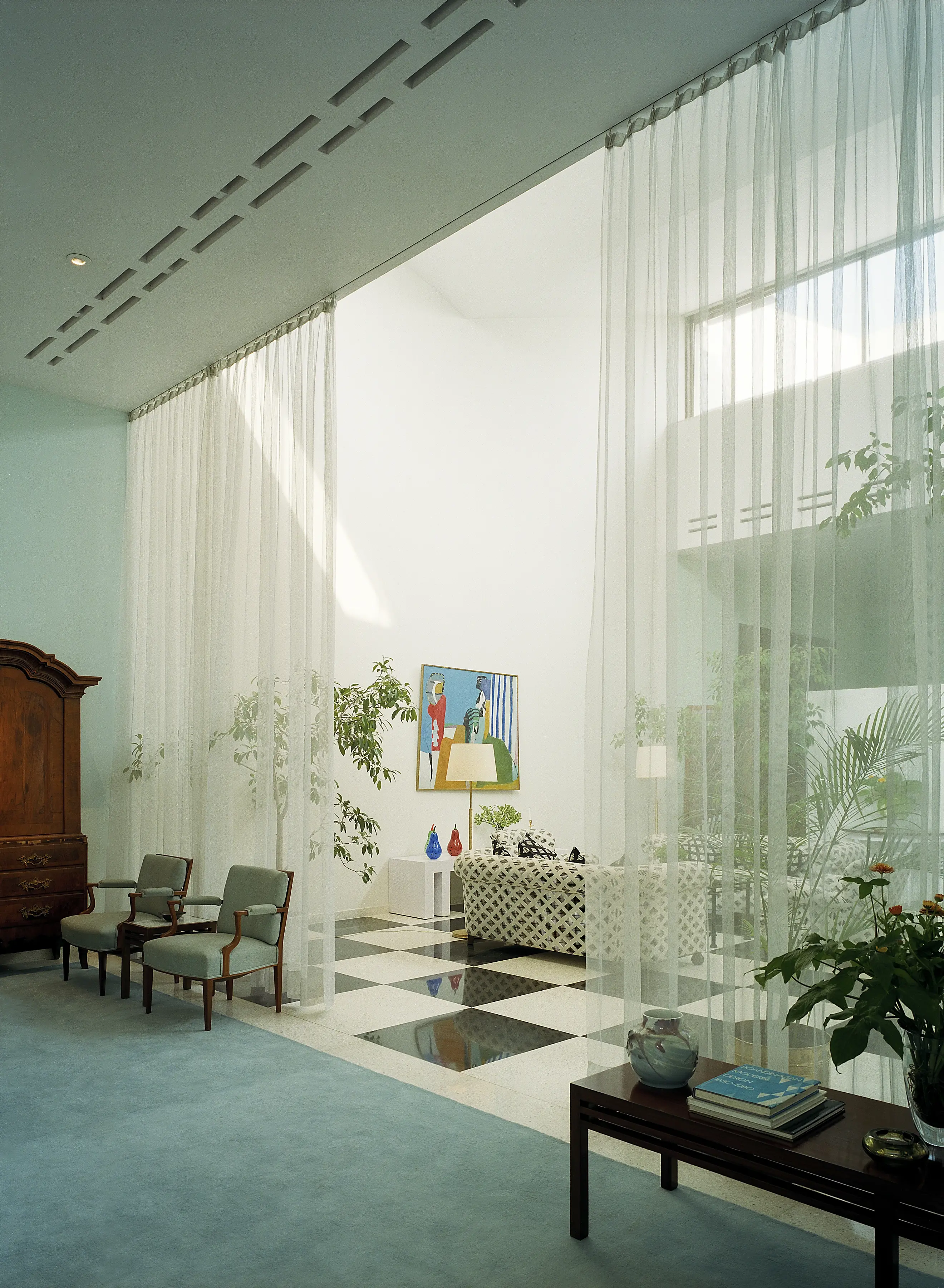 Interiör, ambassaden i New Delhi. Sällskaps-utrymmen som delas av genom olika takhöjd, olika golv-beläggning och tunna draperier.