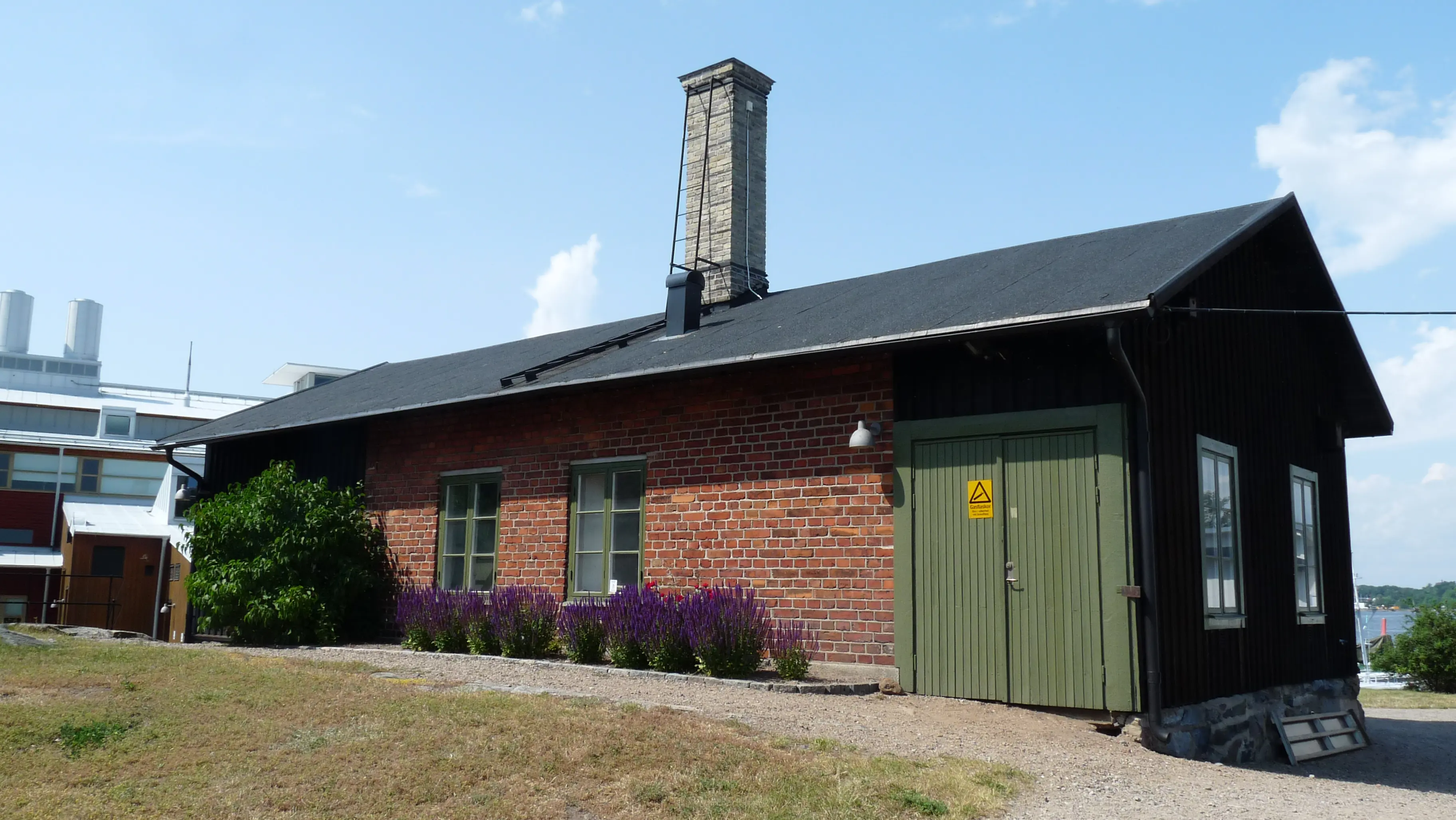 Desinfektionshuset i Karlskrona. En låg tegelbyggnad med en hög skorsten mitt på taket.