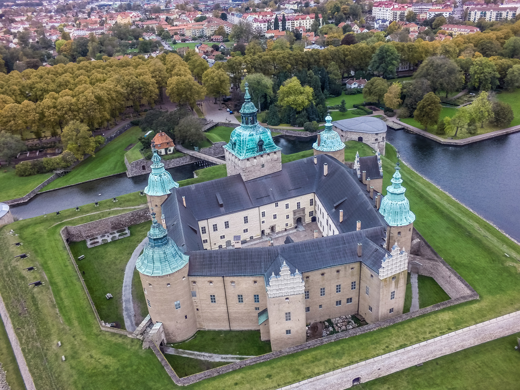 Flygfoto av Kalmar slott, en renässans-borg omgiven av en vallgrav. I bakgrunden syns en park och bebyggelsen i Kalmar.