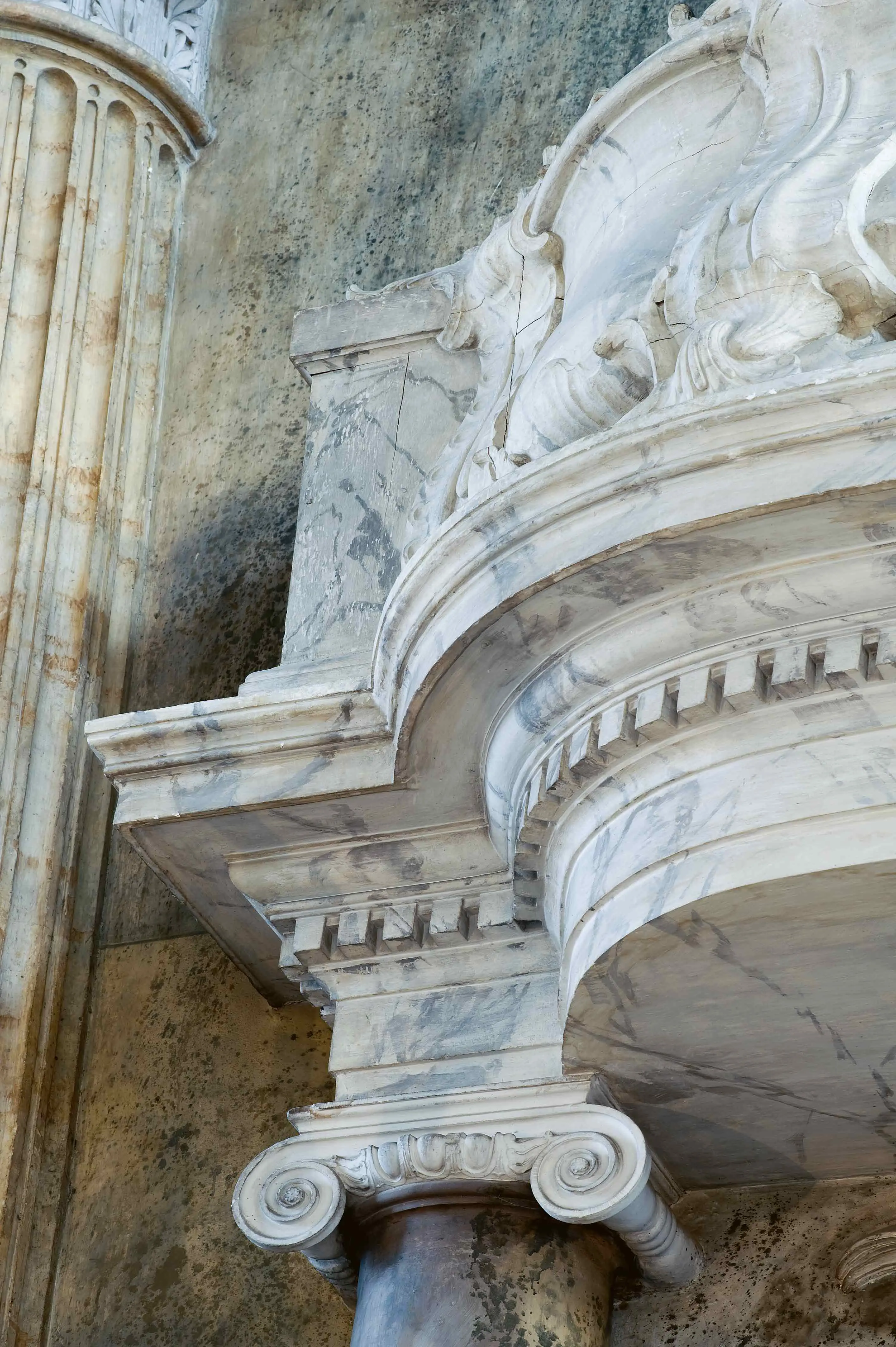 Närbild på en pelare som är målad så att den ser ut att vara byggd i marmor.