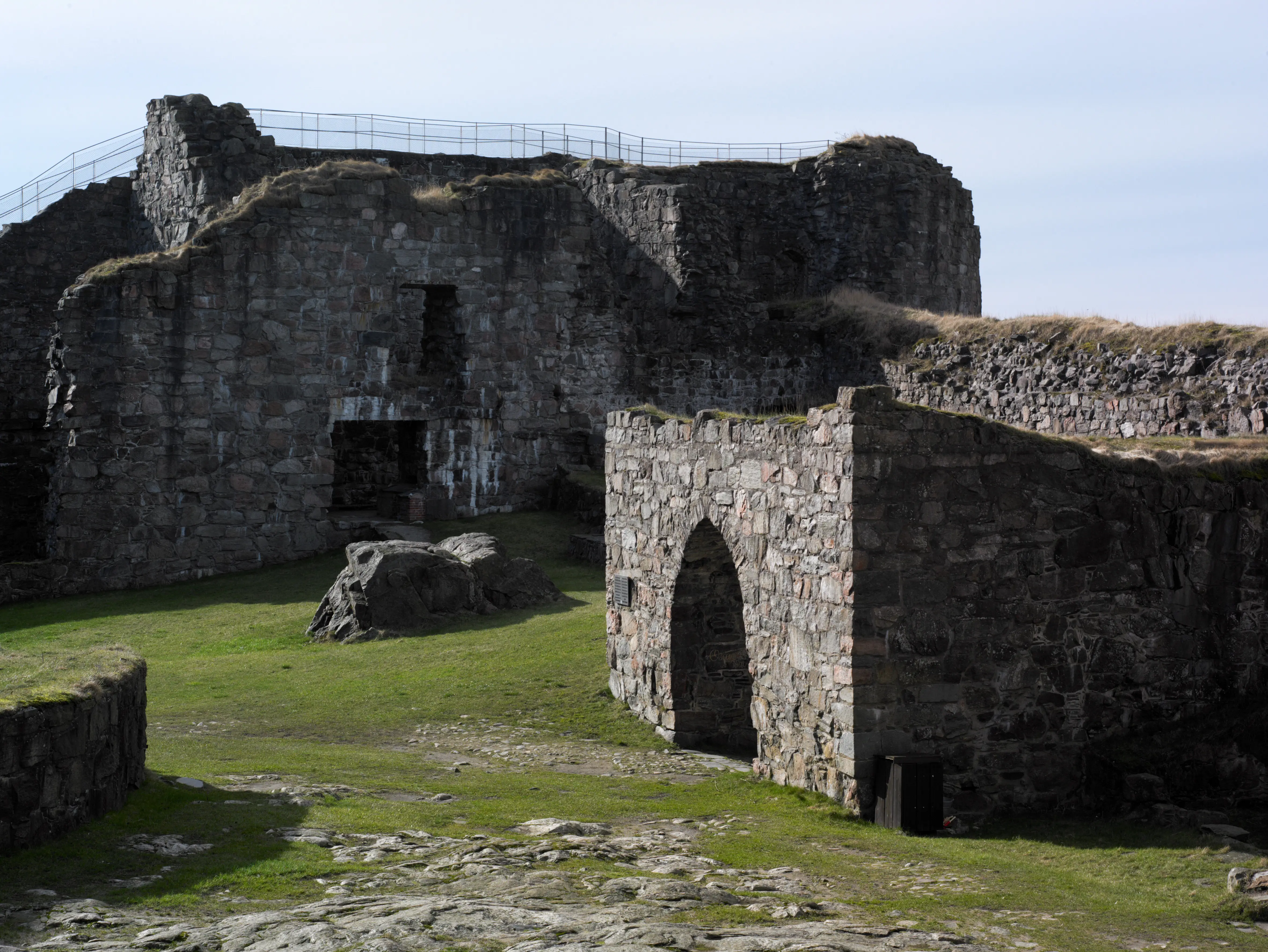 Bohus fästning, medeltida försvarsverk i sten. Murarna är gräsbeväxta och delvis raserade.