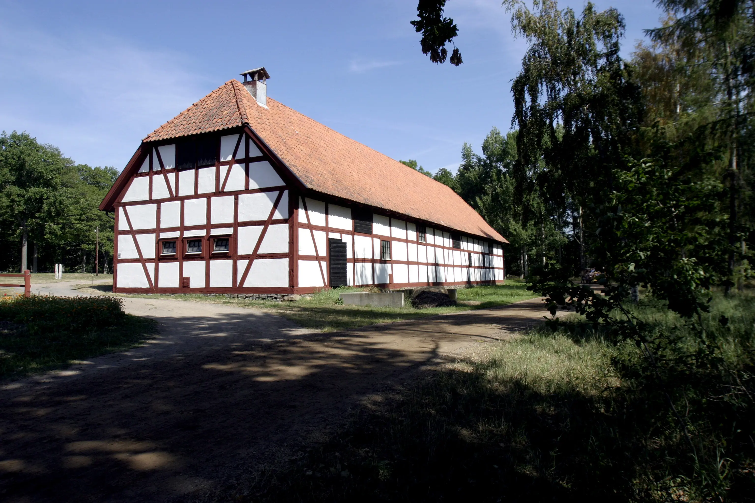 En av Kungsladorna på Visingsö. En vitputsad korsvirkes-byggnad med tegeltak.