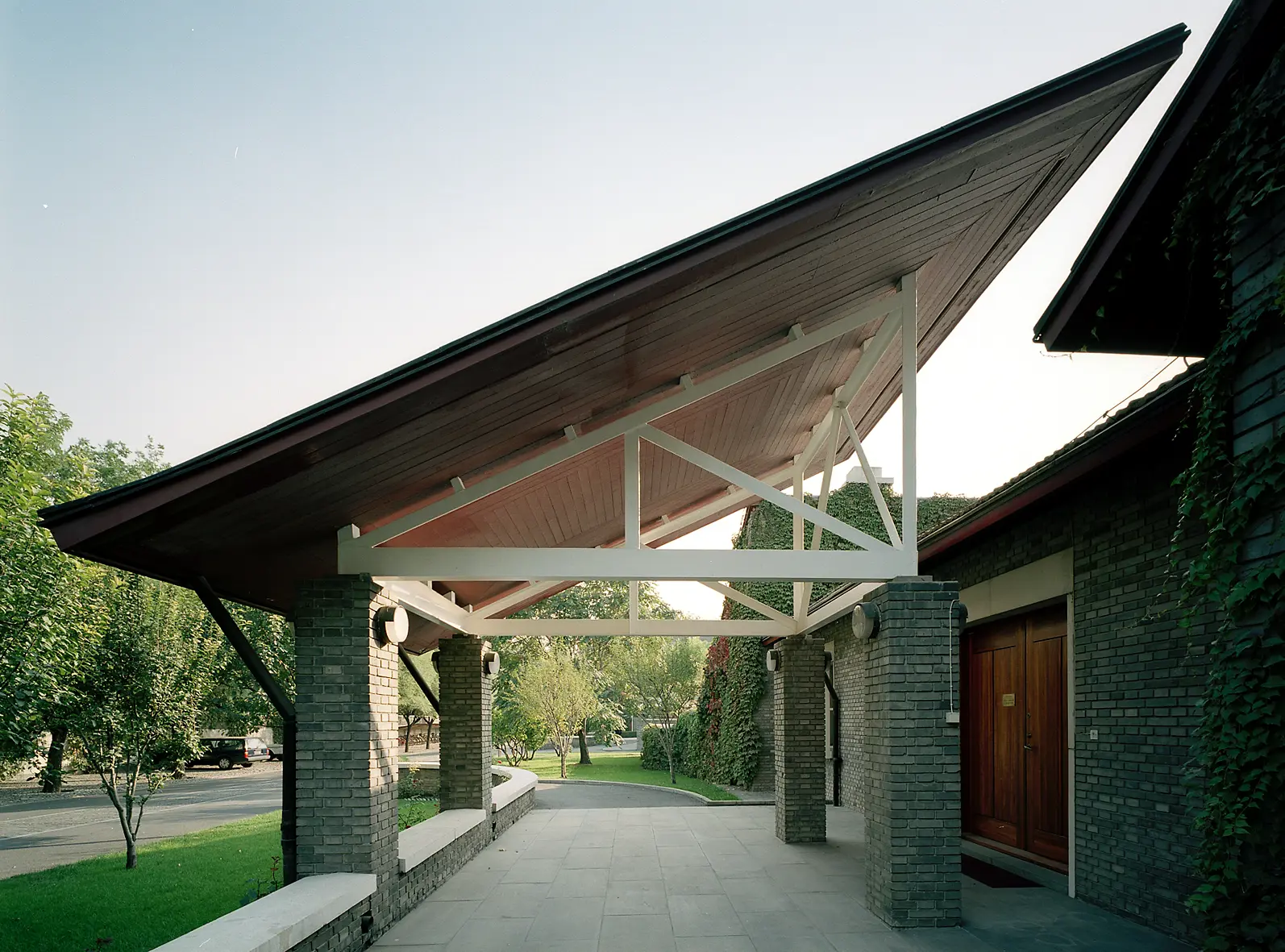 Ambassaden i Peking. Ett stort skärm-tak i trä, på tegel-pelare, skuggar entrén.