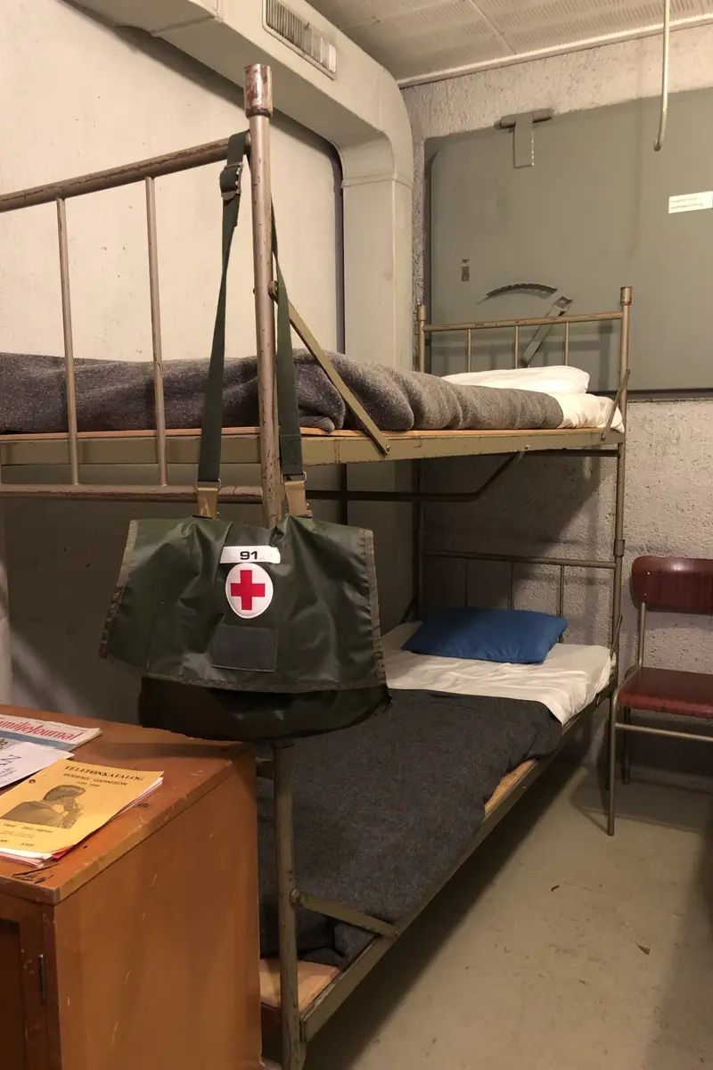 Logement med en våningssäng och en sjukvårdsväska.