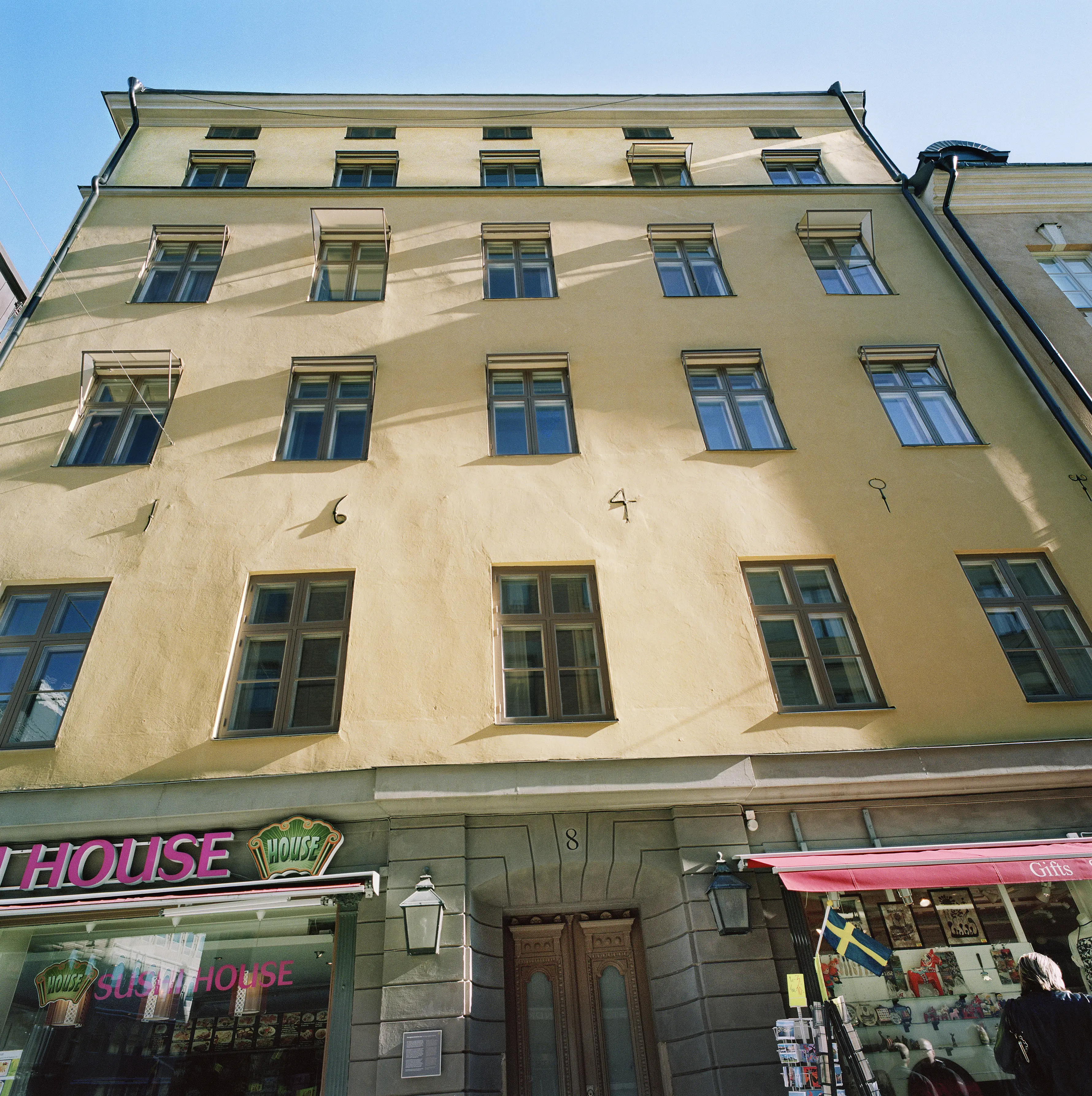 Drottninggatan 8. På fasadens släta, gula puts bildar ankarslut årtalet sextonhundrafyrtio.