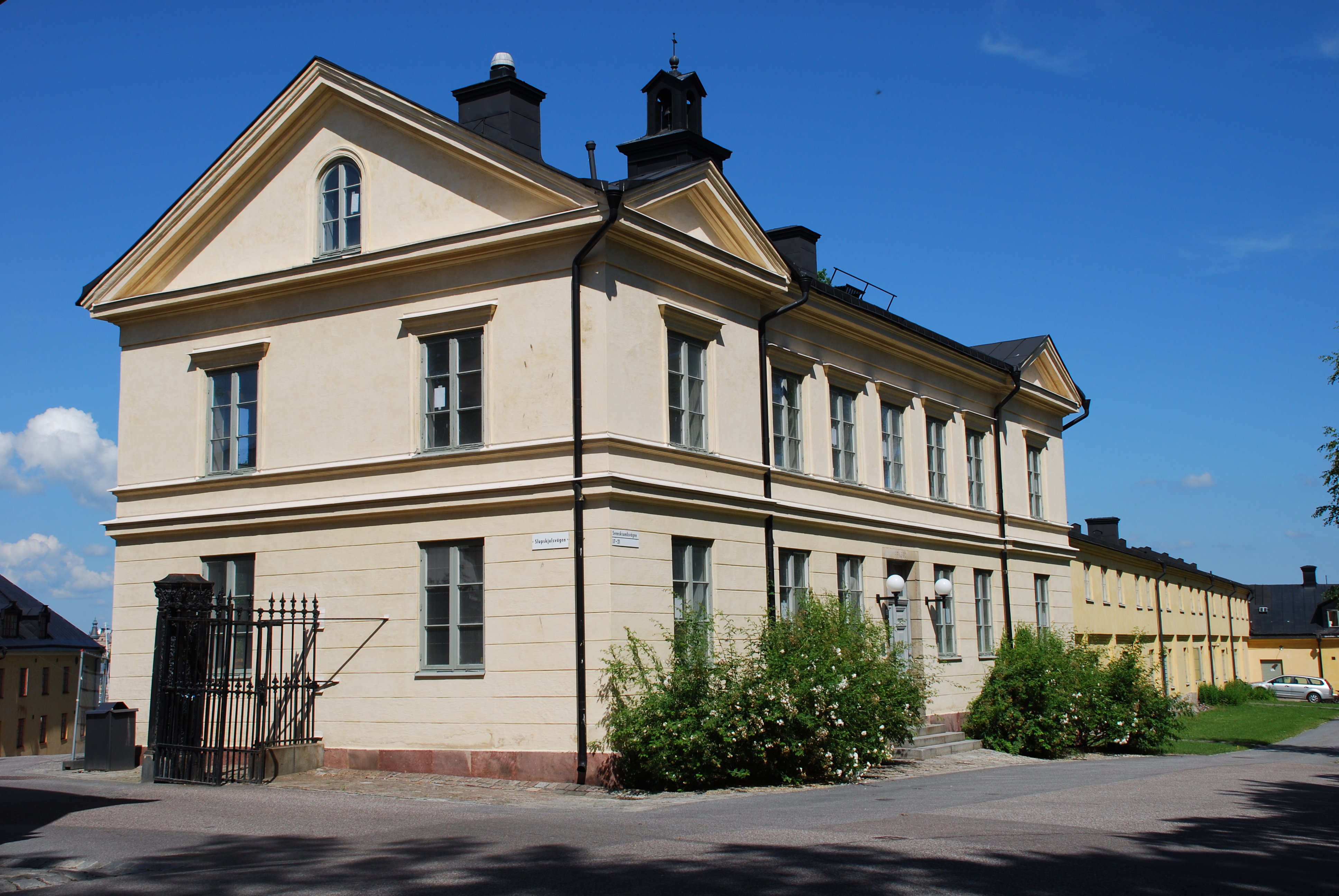 Exteriör östra kanslihuset. Entrén kanstas av rosenbuskar och taket har en lanternin.