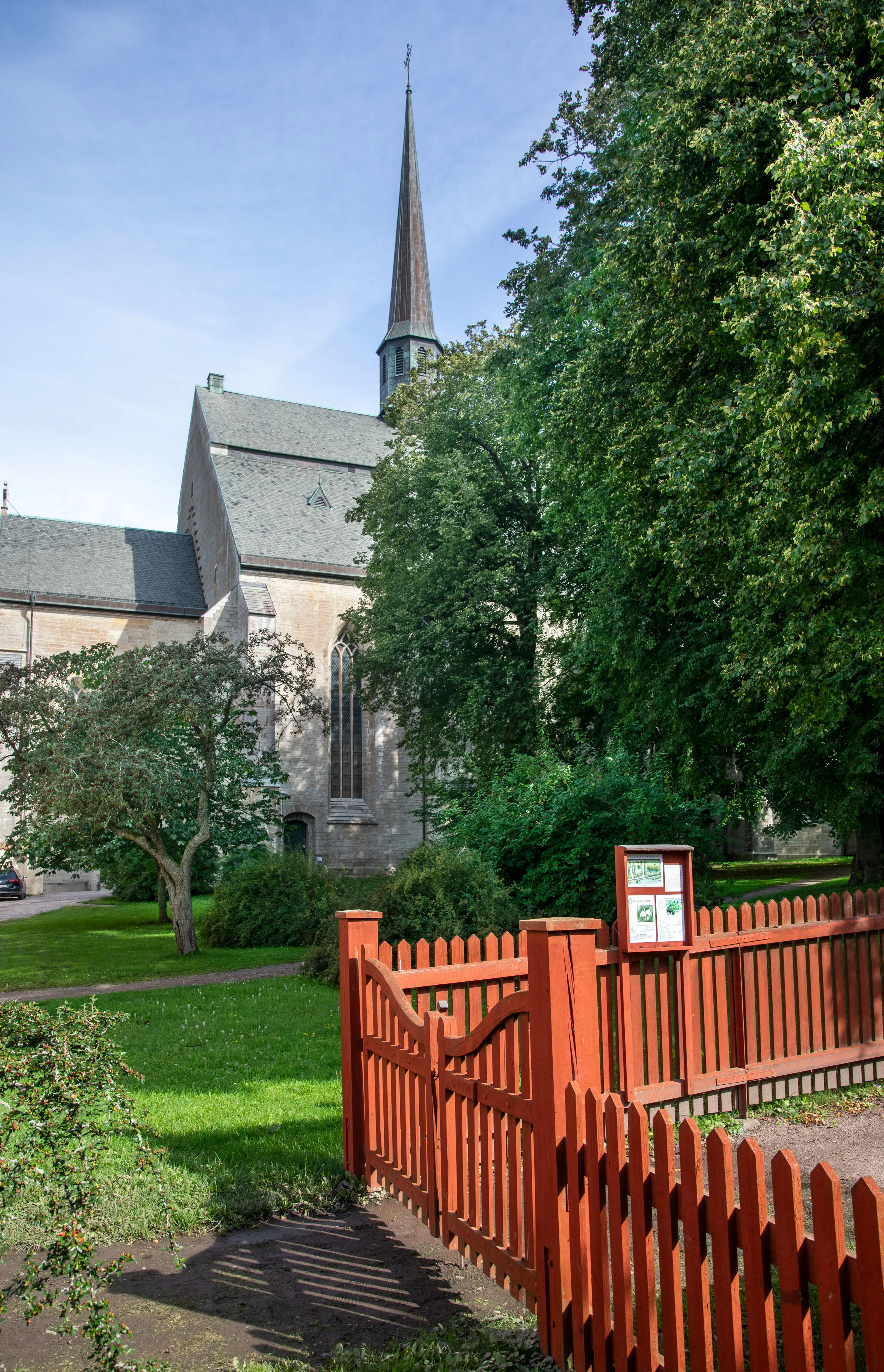 Örtagård med växter planterade i rutindelade rabatter. Grusgångar mellan odlingarna.