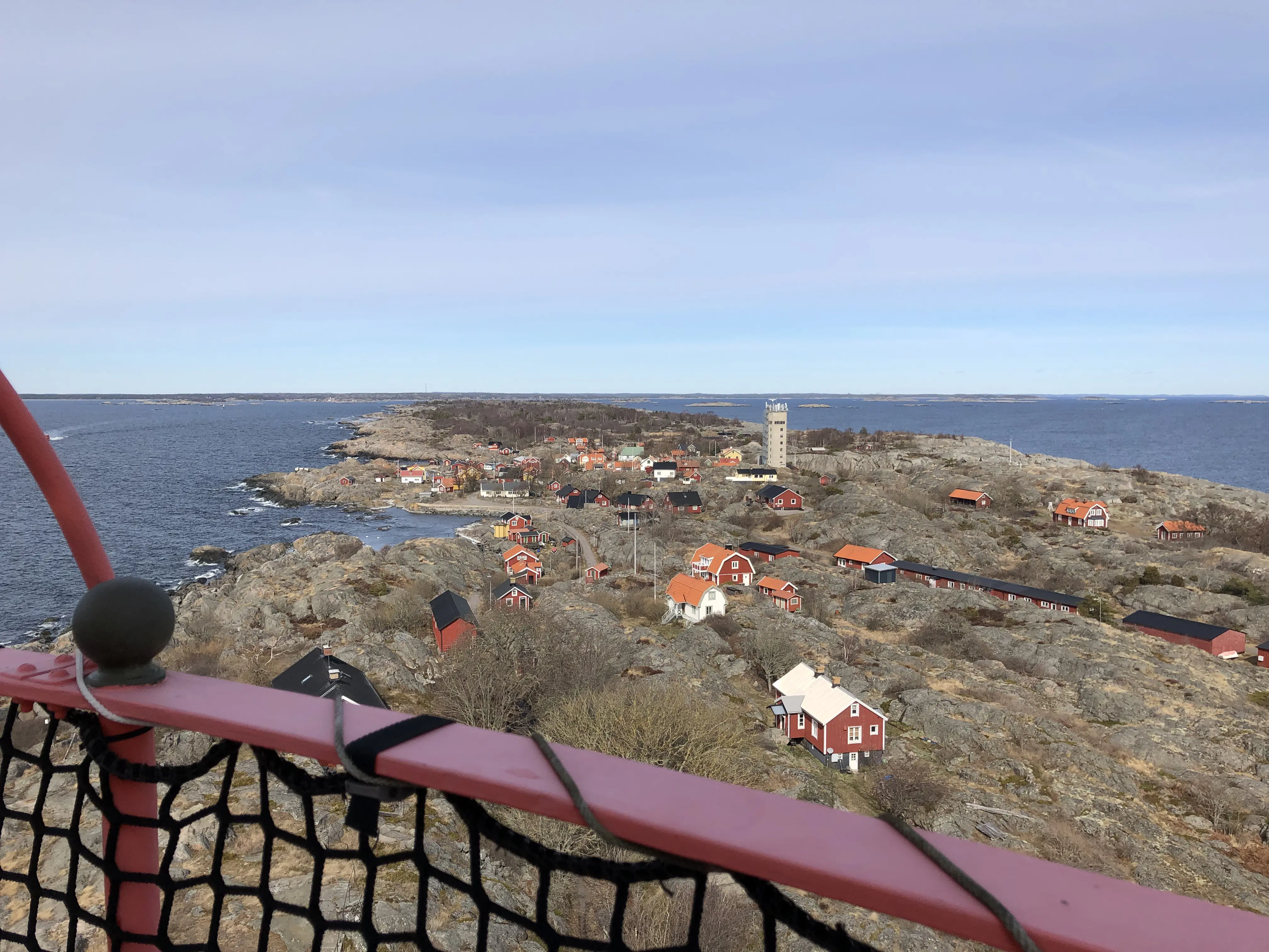 Öja, Stockholms skärgård. Röda och gula trähus av blandad ålder och storlek. Vy norrut, mot lots-tornet och fastlandet.
