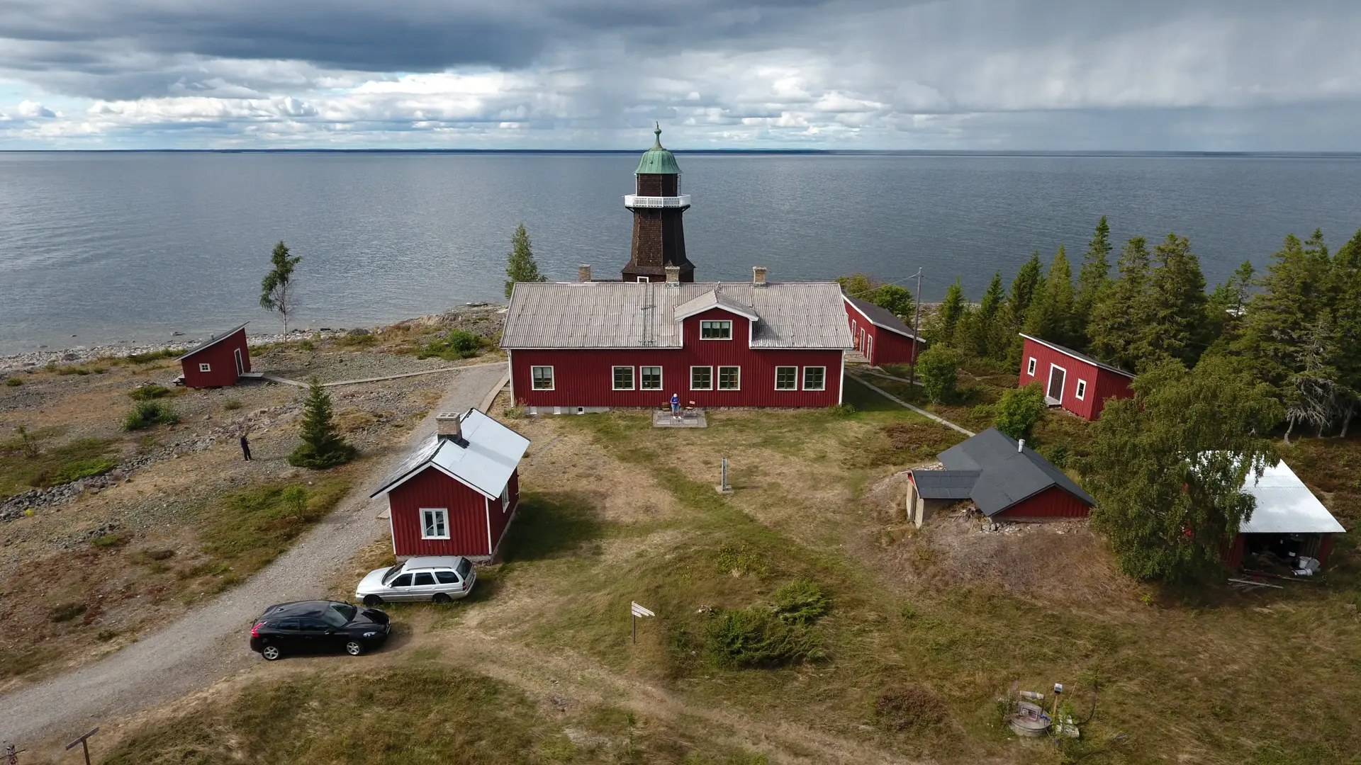 Röda byggnader och en fyr vid vattnet