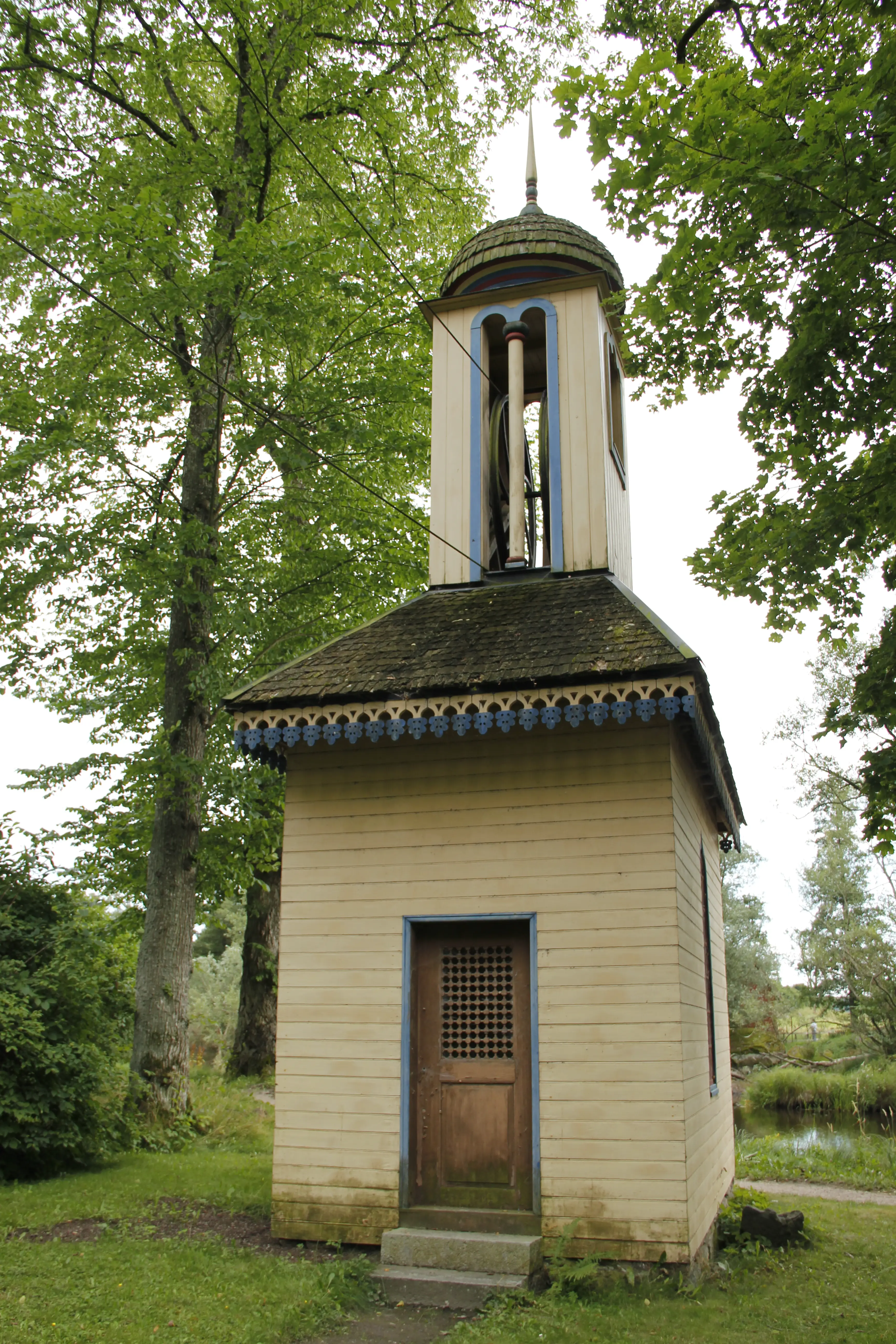 Transmissionshus vid Huseby bruk. En hög, smal träbyggnad med lanternin. En lång stålkabel är uppträdd på ett hjul i lanterninen.