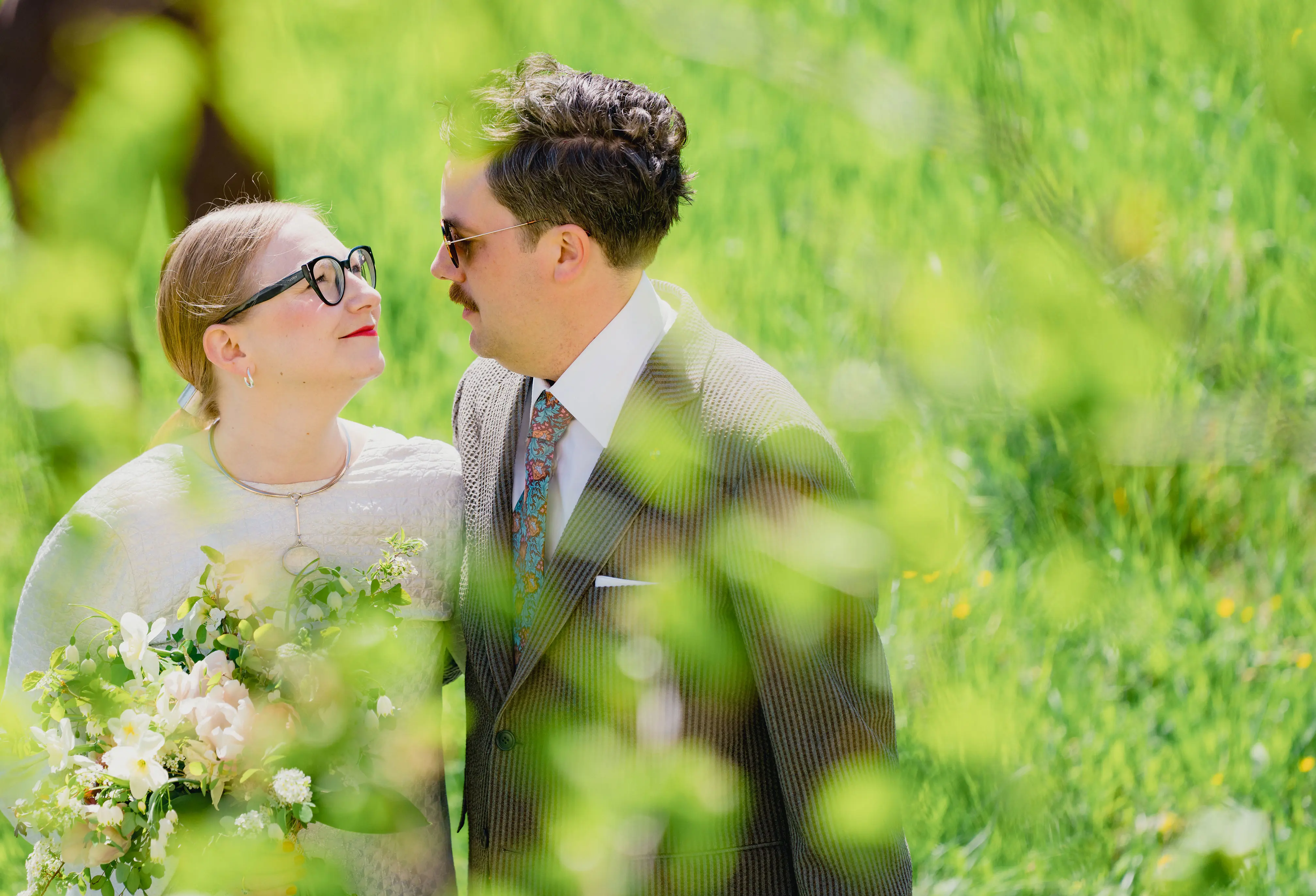 Nygift par mot grönskande för- och bakgrund.