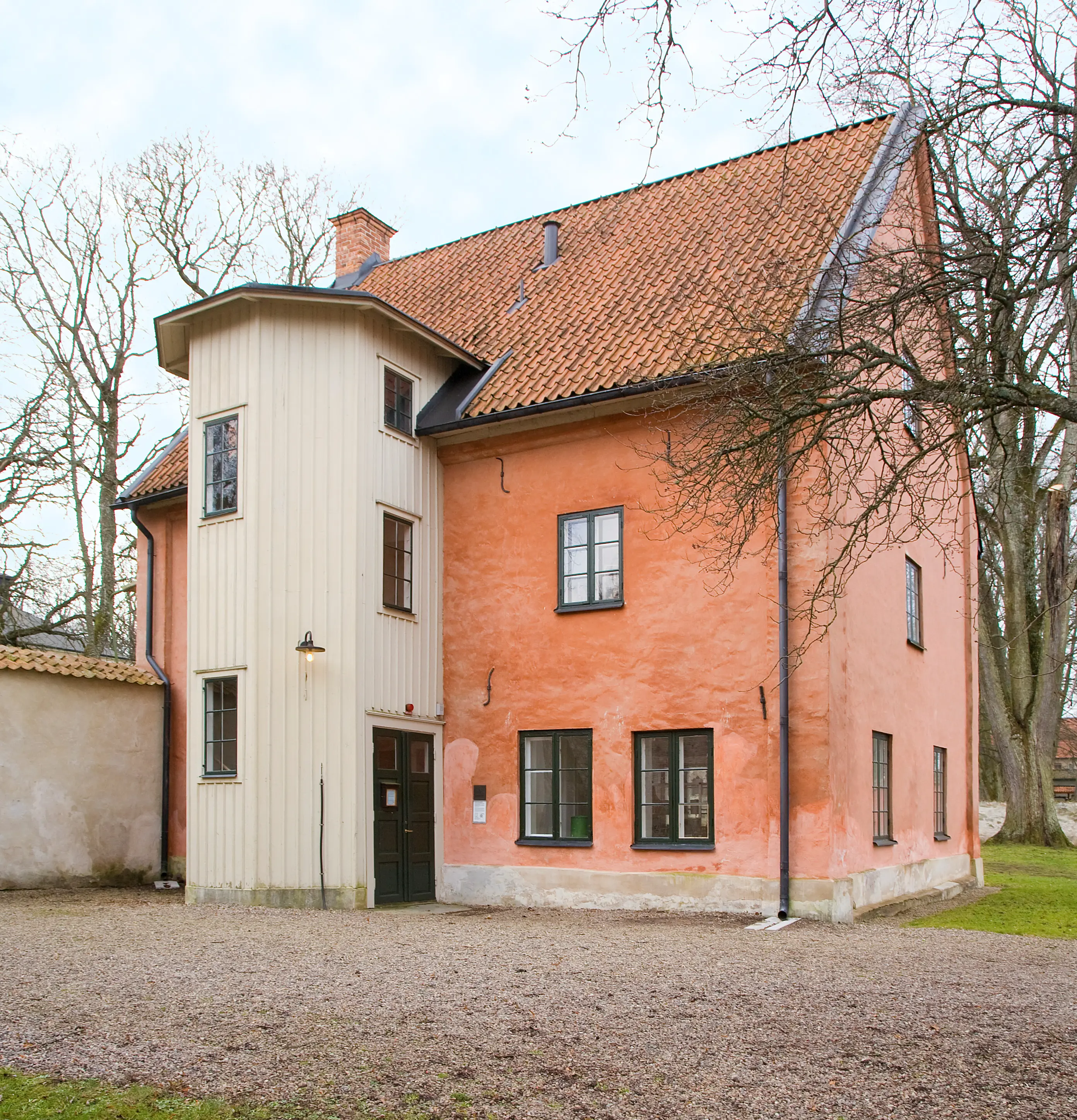 Hospitalsmuseet, Vadstena. En tvåvåningsbyggnad i brun puts, med brant tegeltak. Ett trapphus i vitt trä är tillbyggt på ena långsidan.