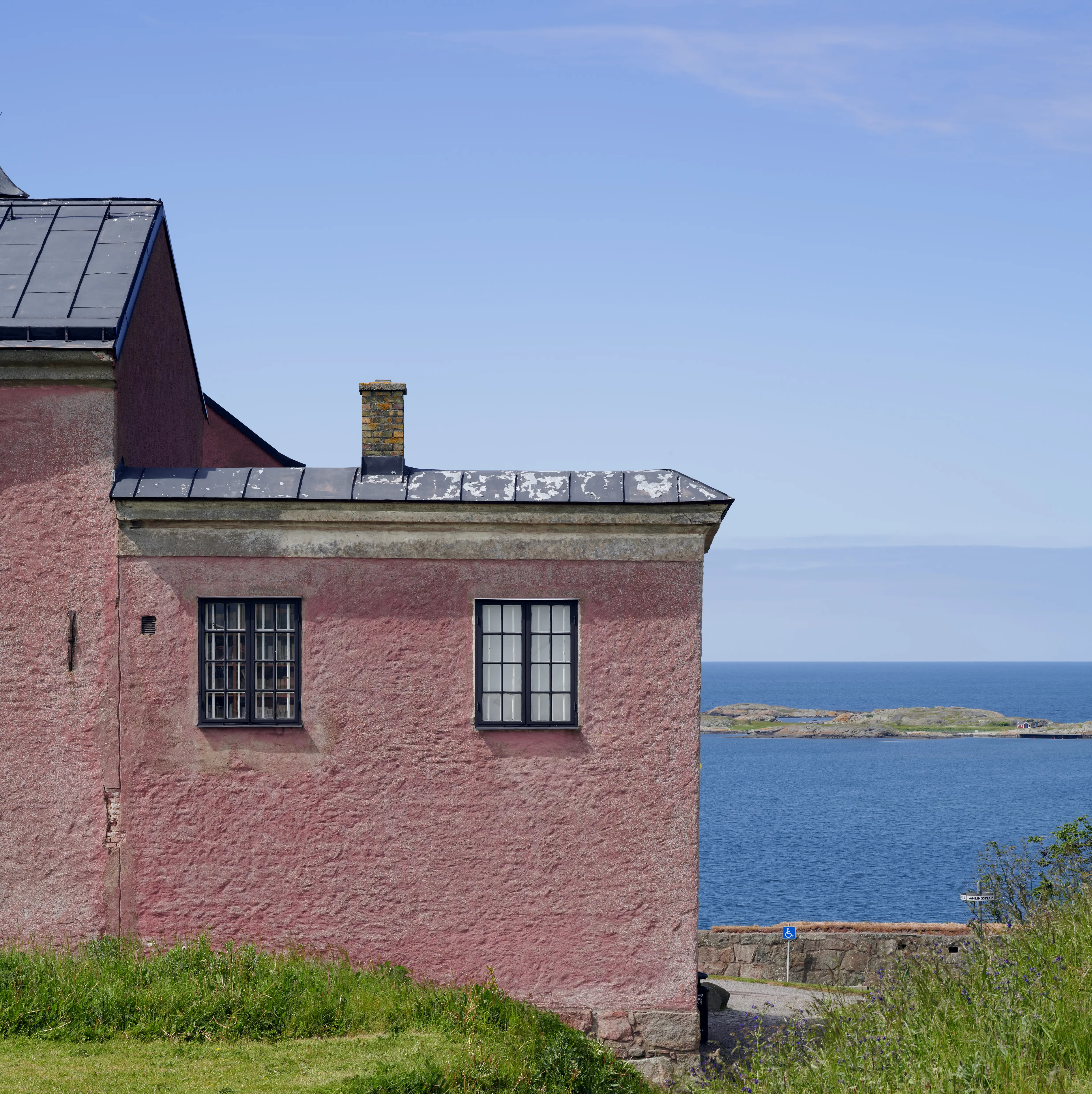 Varbergs fästning, en del av slottet med sin röda puts. Bakom byggnaden syns havet.