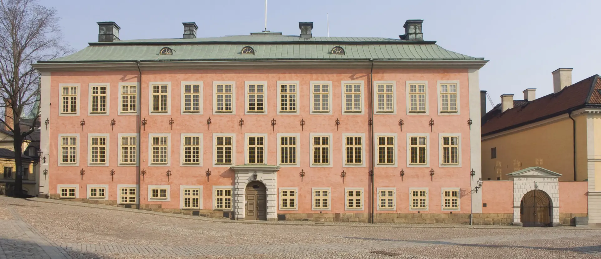 Stenbockska huset med sin rosa fasad. På marken ligger kullersten.