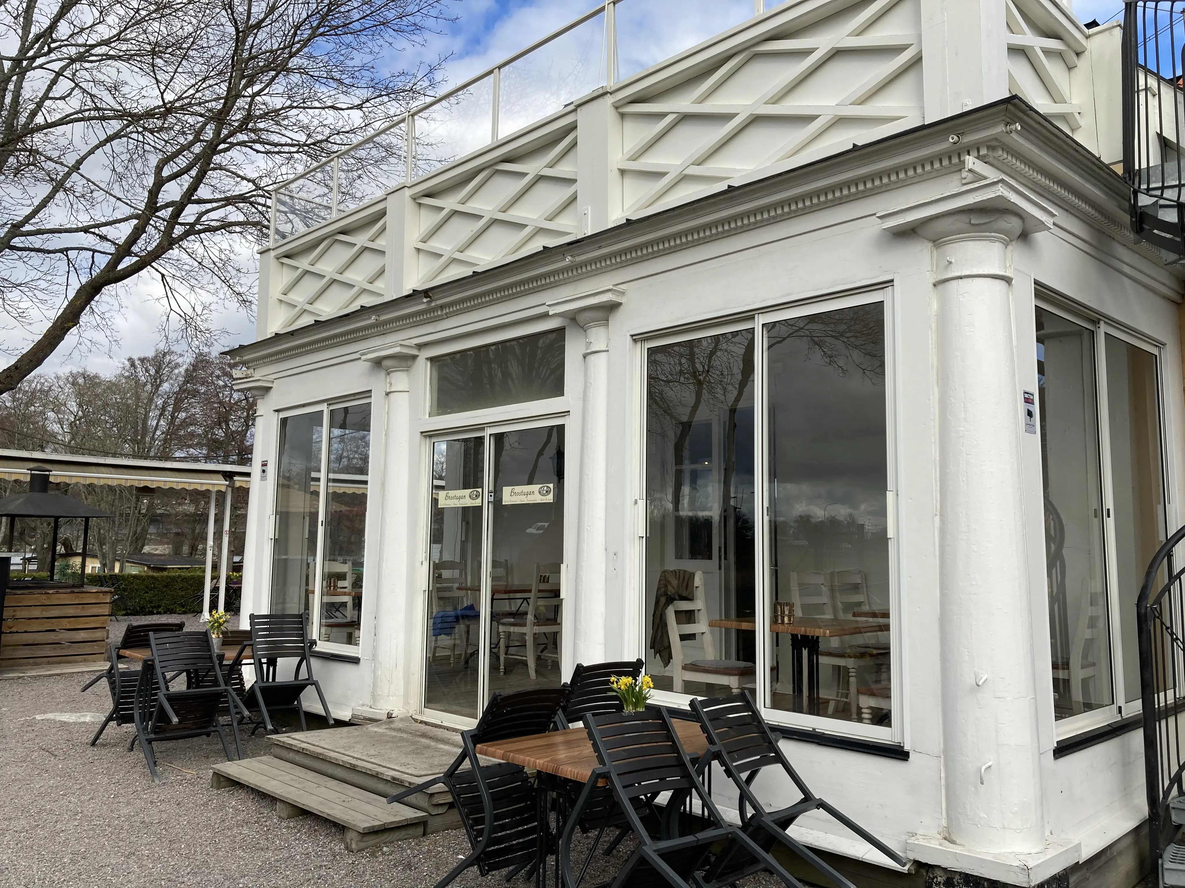 Brostugan på Kärsön. Glasverandan i tjugotals-klassicistisk stil, med balkong på taket, är byggd i vitmålat trä.