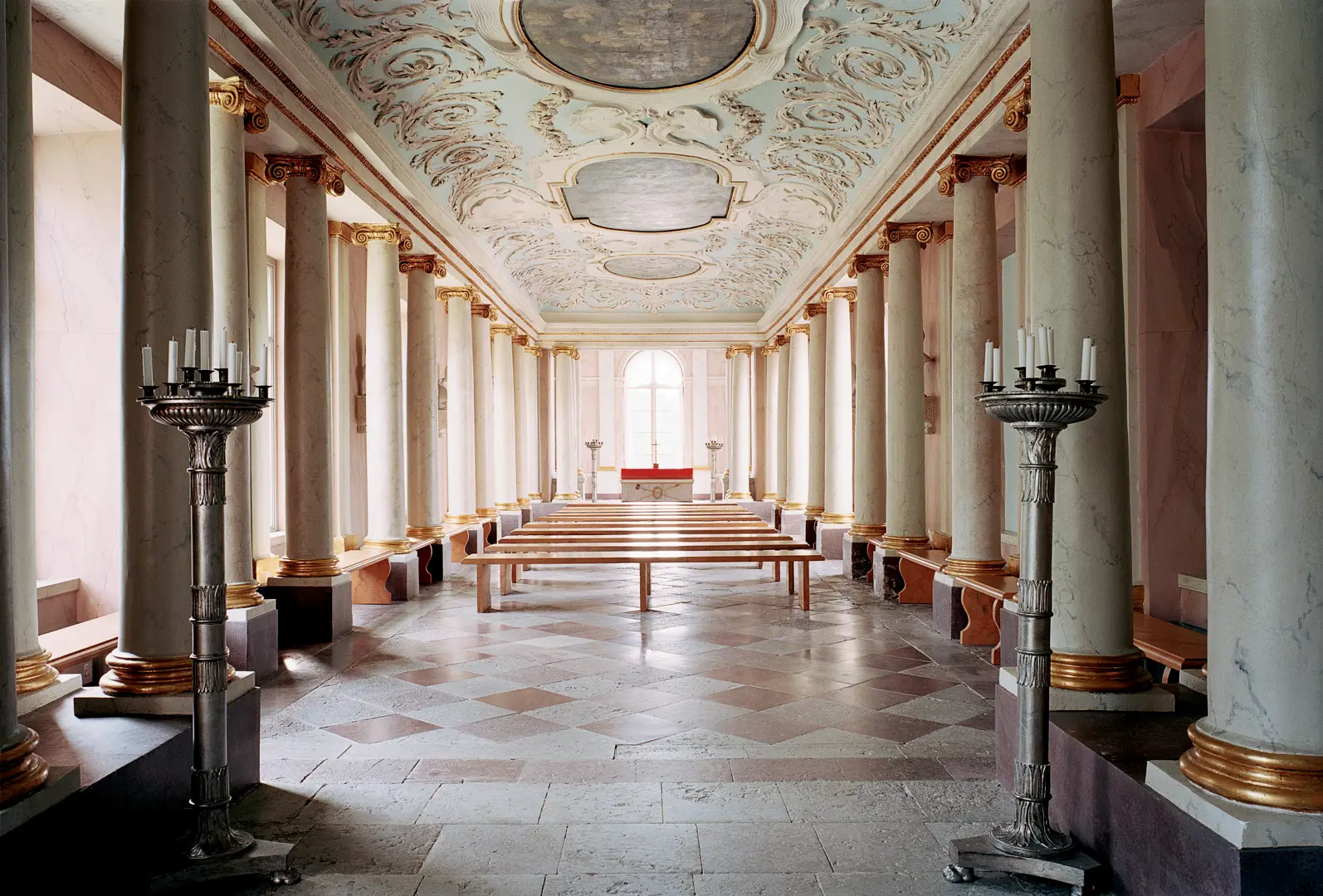Slottskapellet på Rosersbergs slott. En avlång sal med takdekorationer. Längs väggarna står pelare av marmor med förgyllda detaljer.