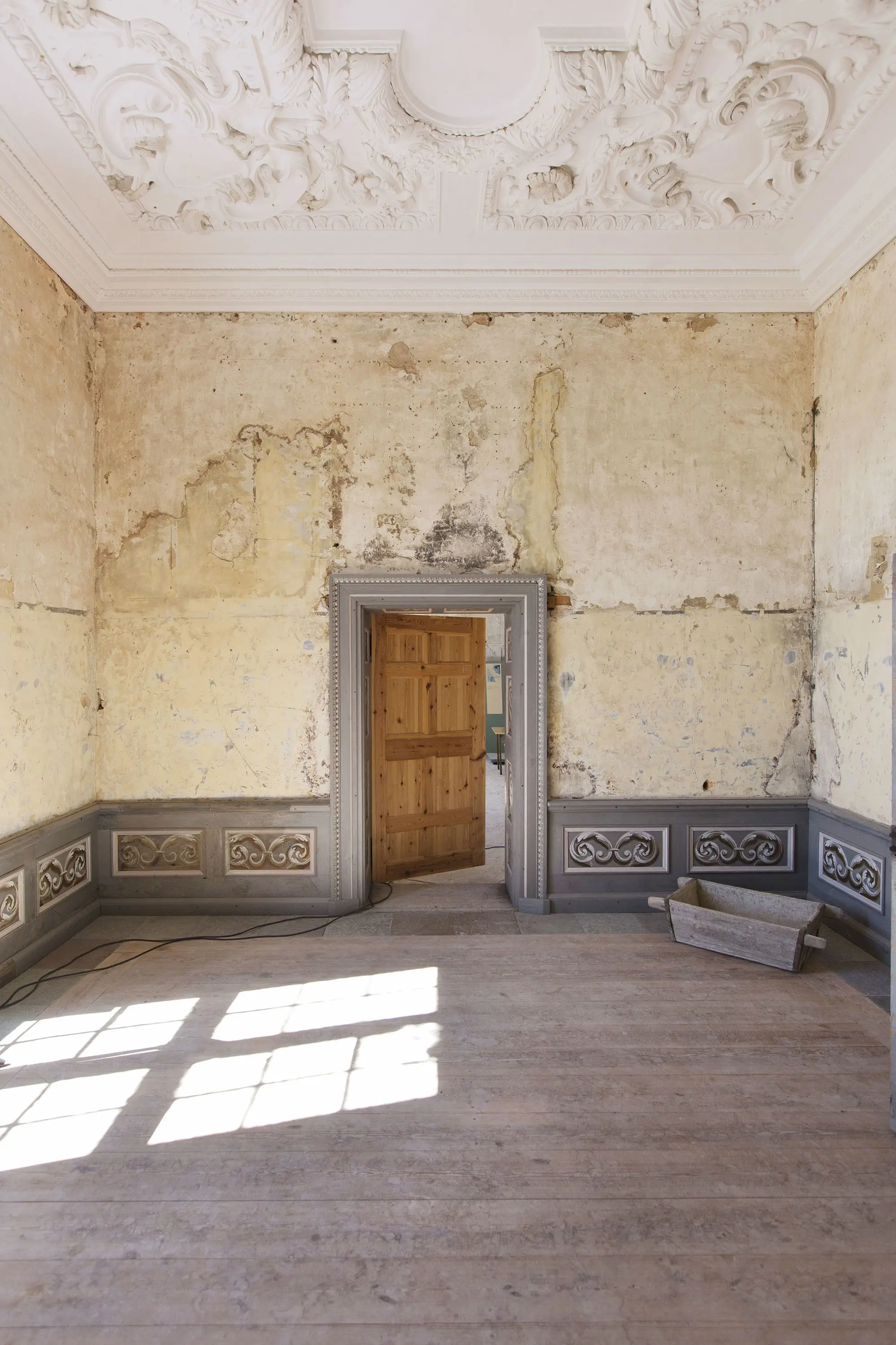 Interiör, Mälsåkers slott. Delvis restaurerat rum med stuckatur i taket och låg, målad panel längs väggarna.