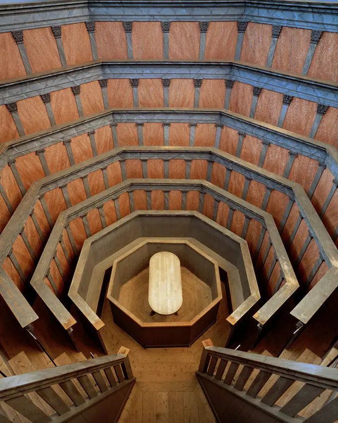 Interiör, anatomiska teatern, Gustavianum. Inredning byggd som en brant amfiteater kring en åttakantig avbalkning med ett bord.