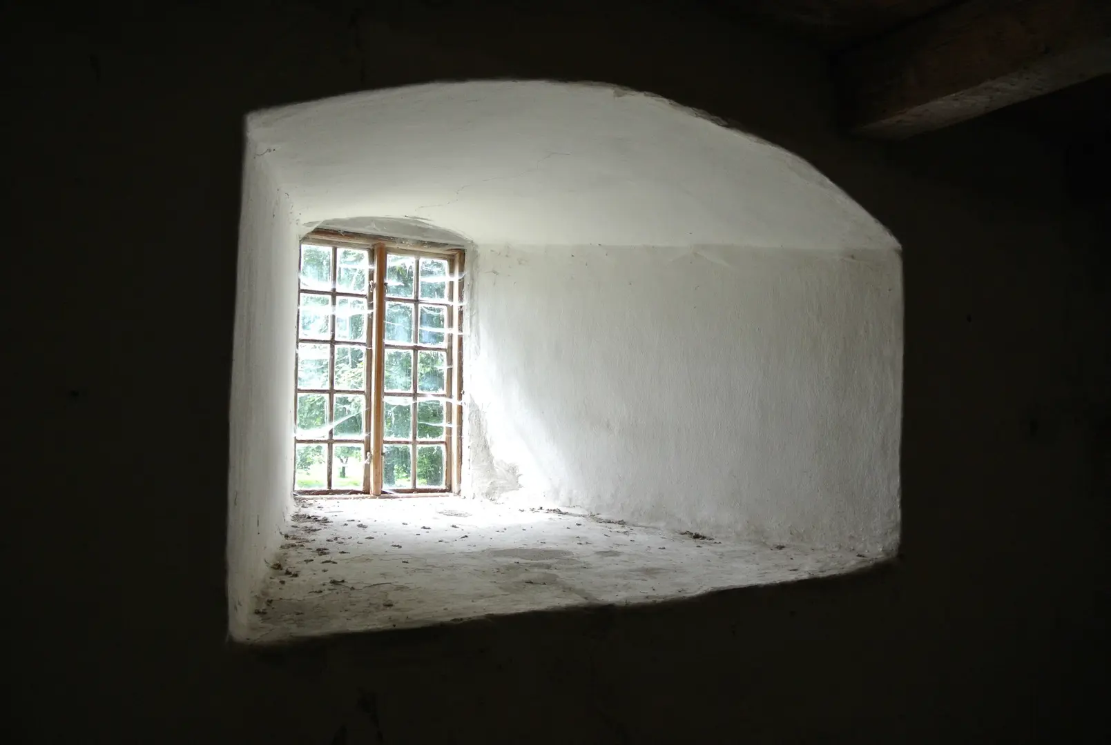 Dagsljus kommer in genom ett spröjsat fönster.