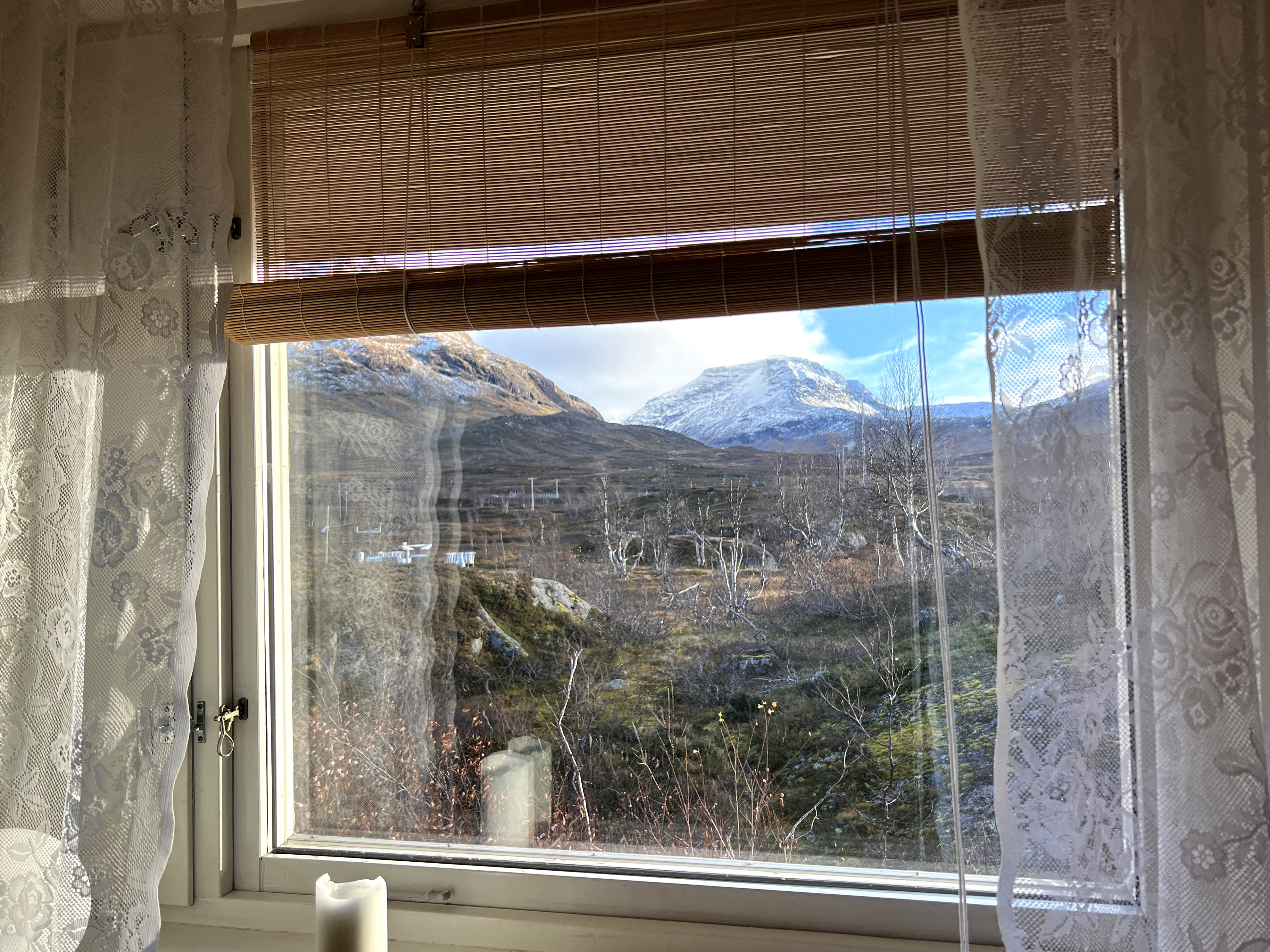 Utsikt över ett fjällandskap genom ett fönster.