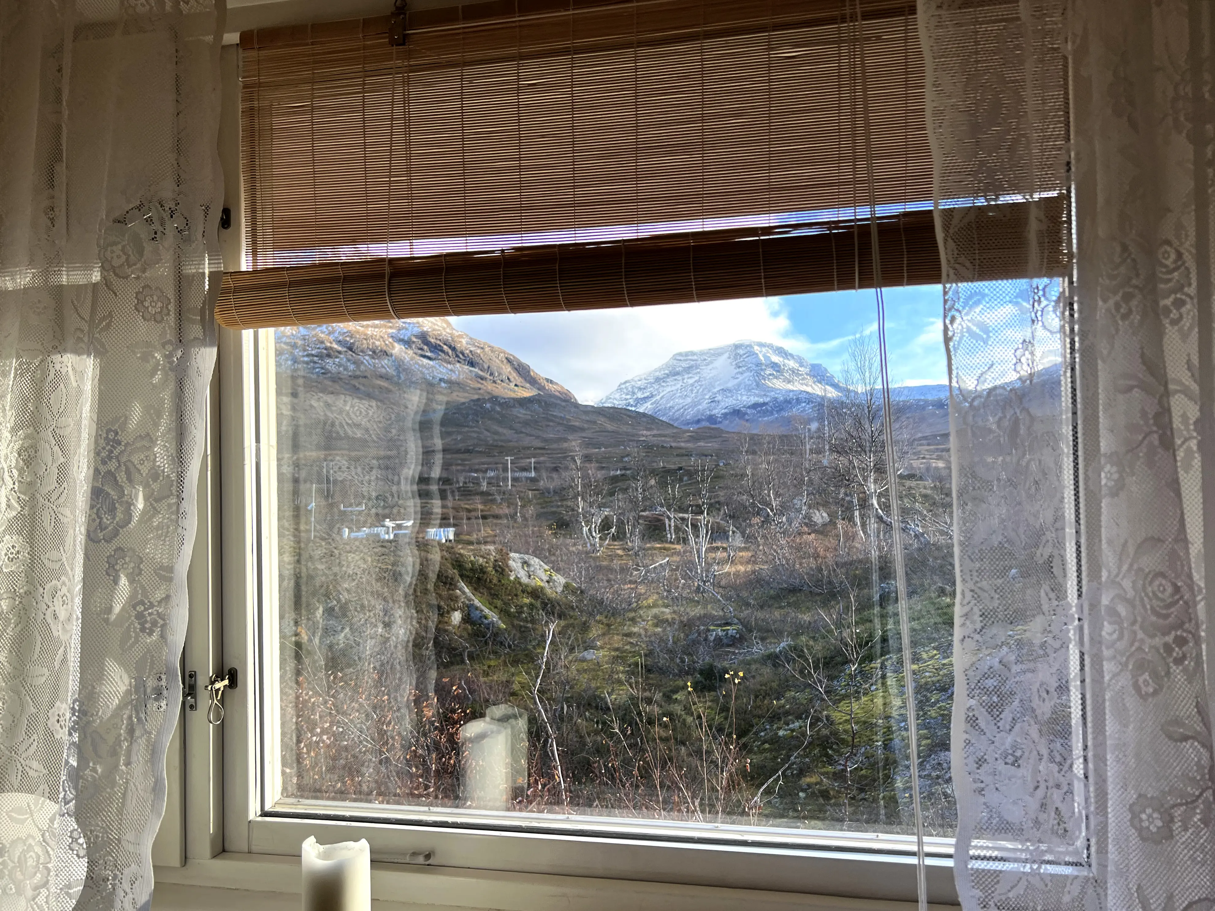Utsikt över ett fjällandskap genom ett fönster.