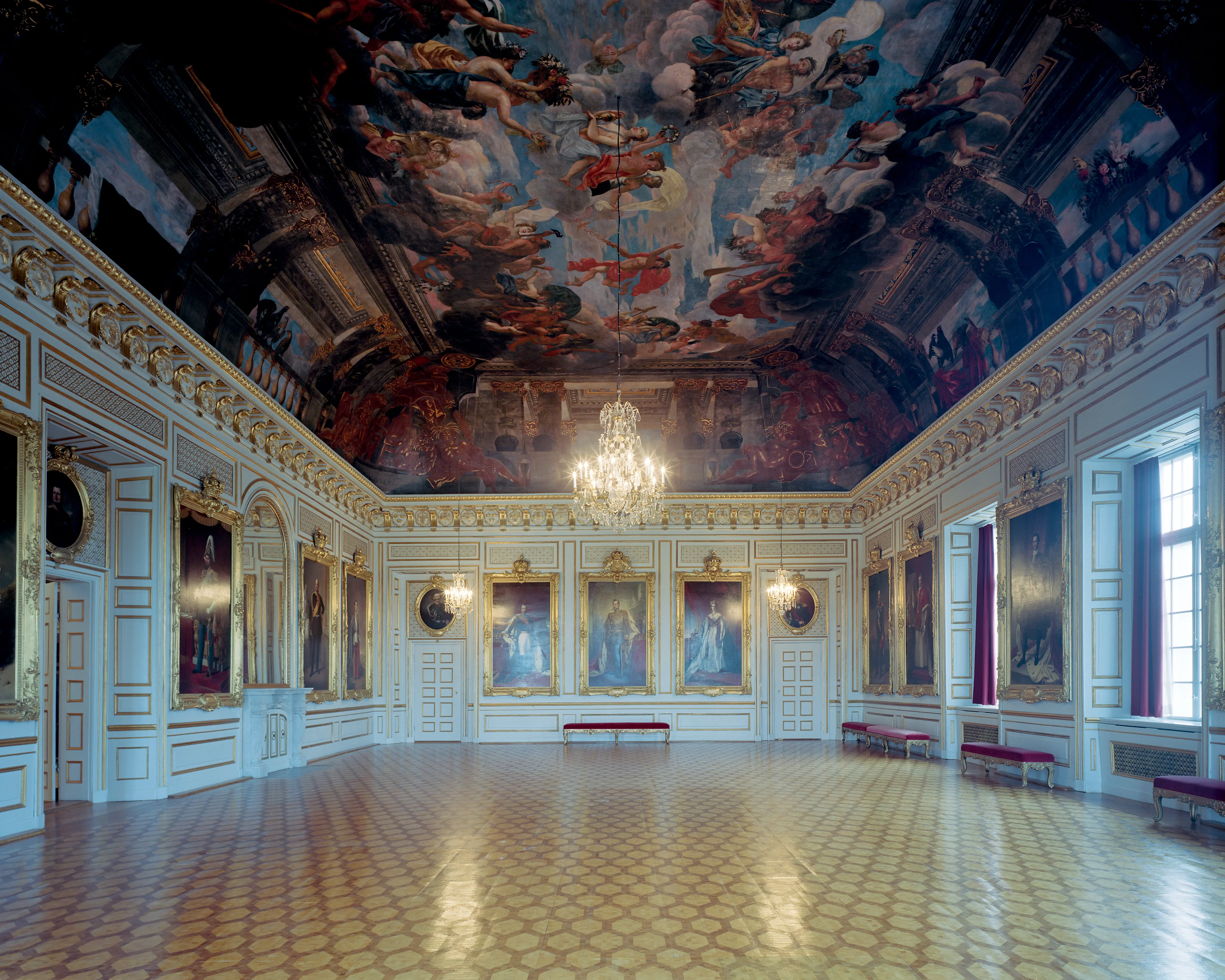 Riks-salen i Drottningholms slott. I taket en målning av Olympen. Väggarna pryds av stuckatur, förgyllningar och stora porträtt.