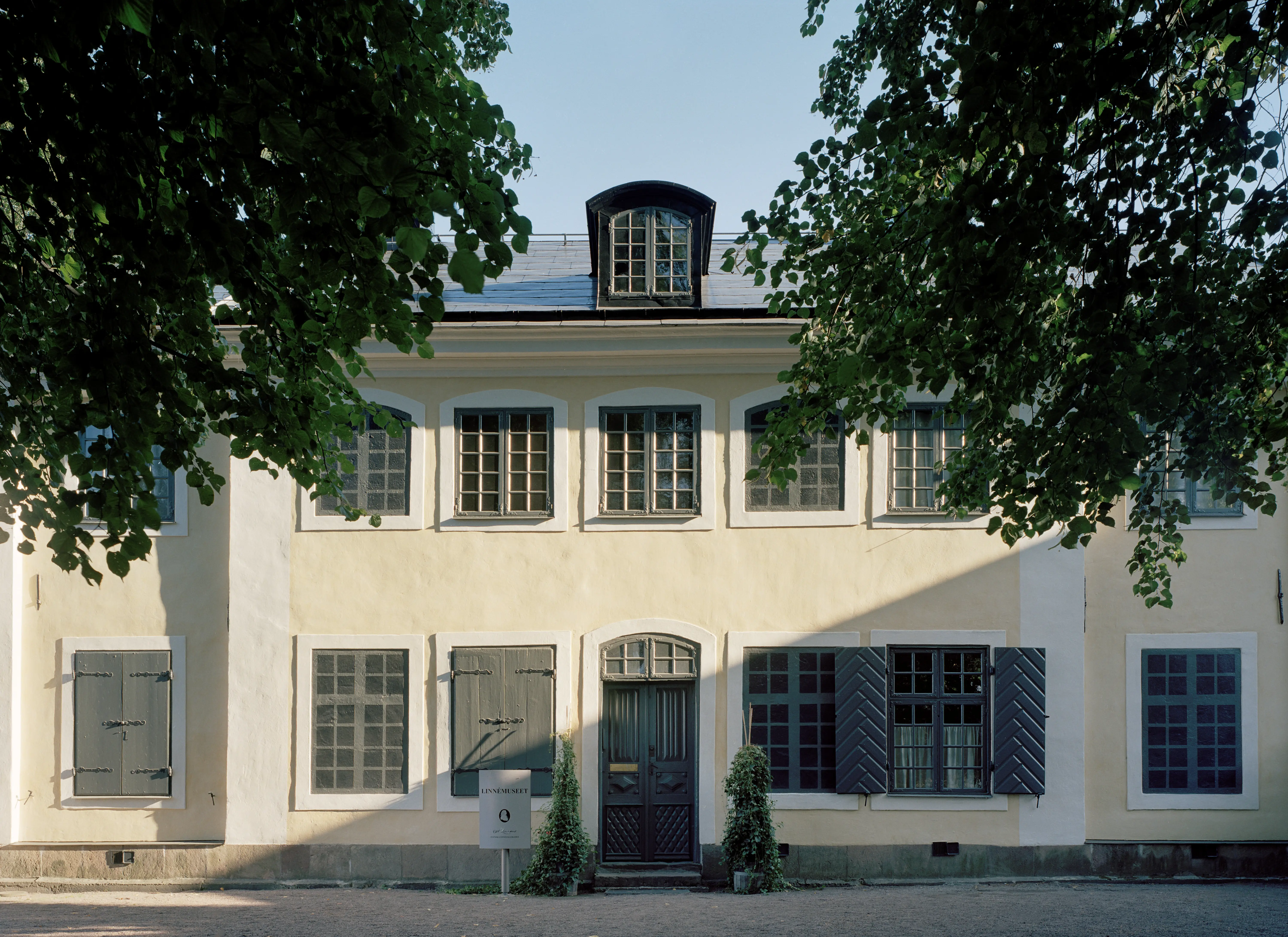 Linnémuseet i Uppsala. Tvåvåningsbyggnad i gul puts. Fasaden är utsmyckad med blinderingar och en tak-kupa.