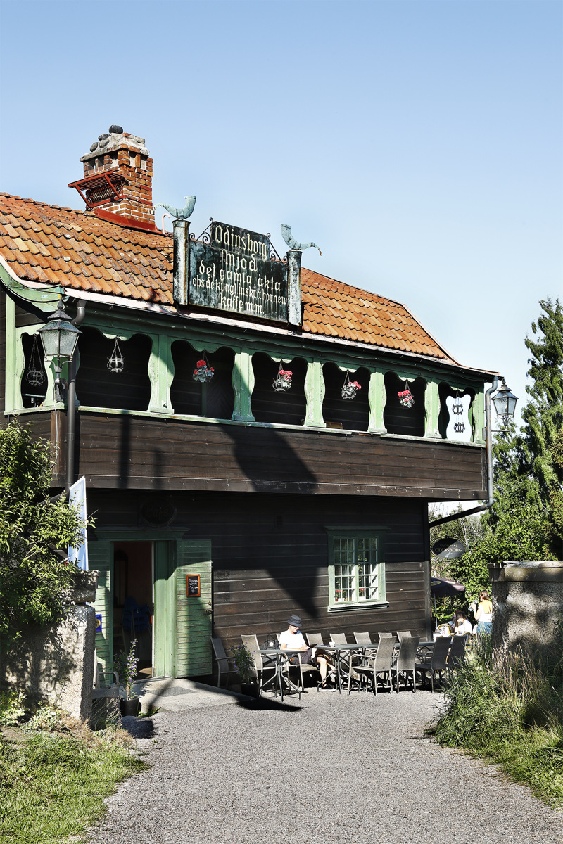 Odinsborg. En nationalromantisk timmerbyggnad med utskjutande loftgång. Fasade är brun med gröna snickerier.