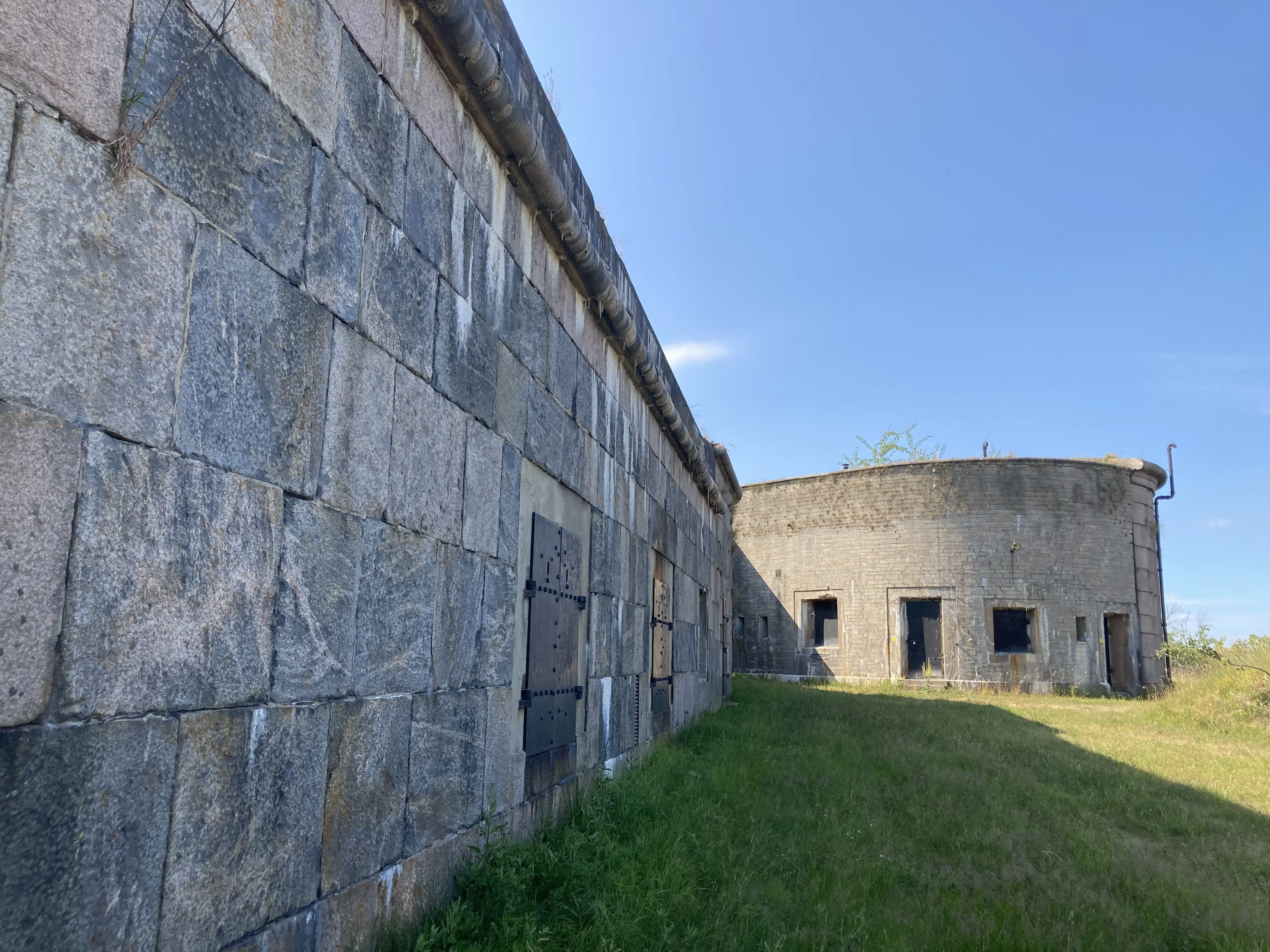 Stenfasaden i fästningen mot gräsyta