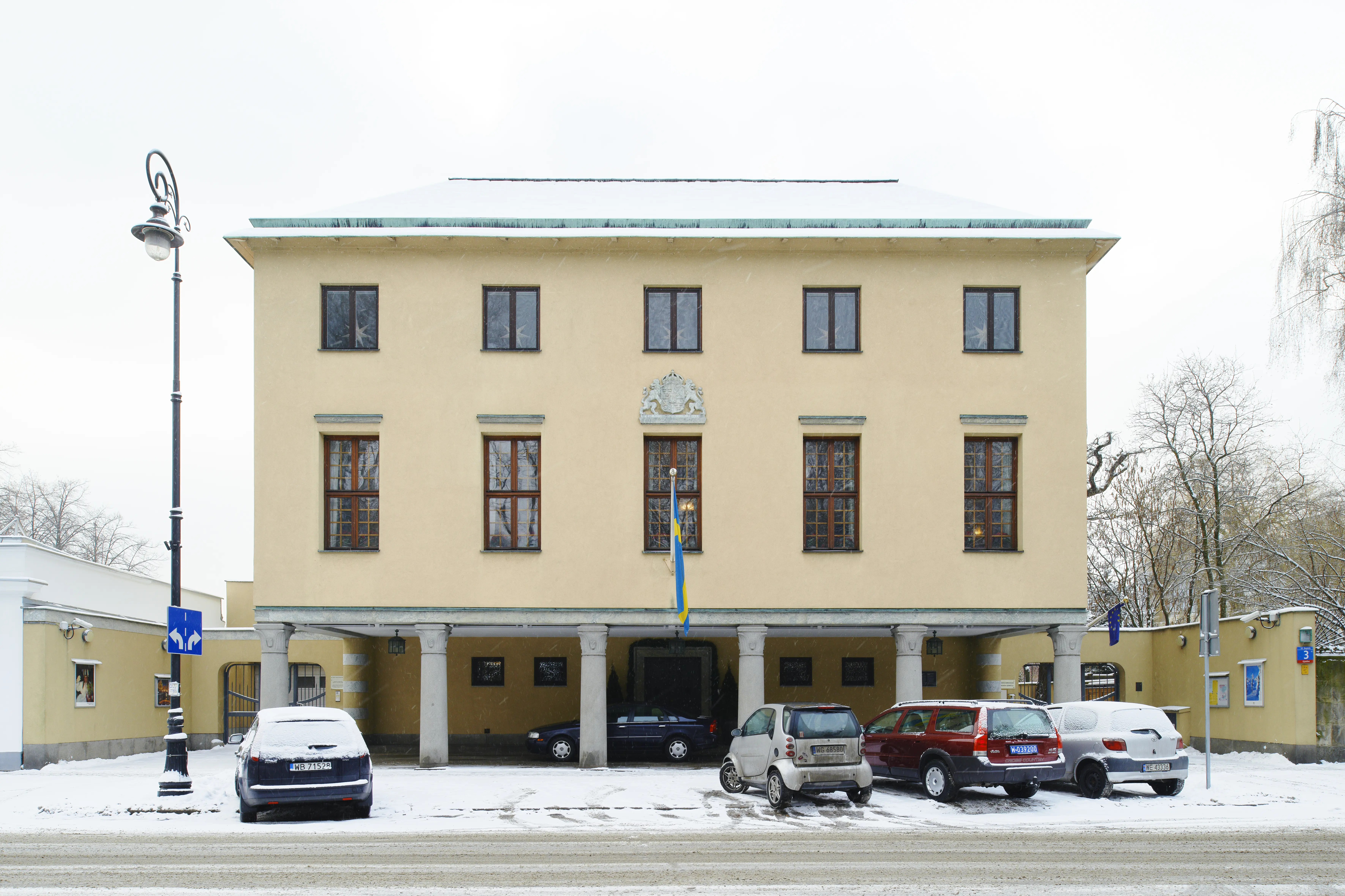 Ambassaden i Warszawa. Exteriör. Entréfasadens bottenvåning är indragen innanför en rad kolonner. Vinter och snö.