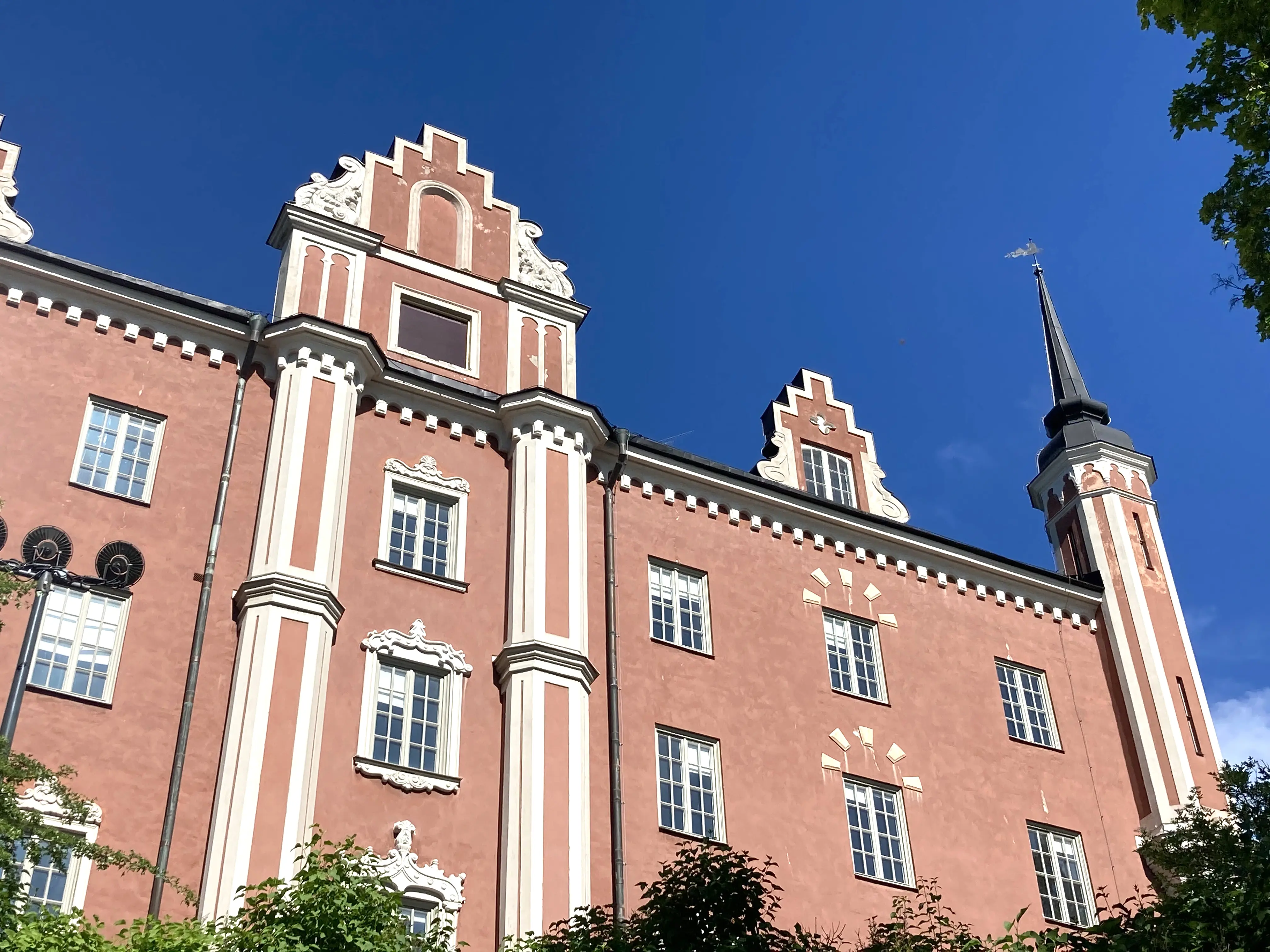 Amiralitetshuset på Skeppsholmen. Brunputsad byggnad med hörntorn och praktgavel i nyrenässans-stil. Fasaden har vita dekorationer.