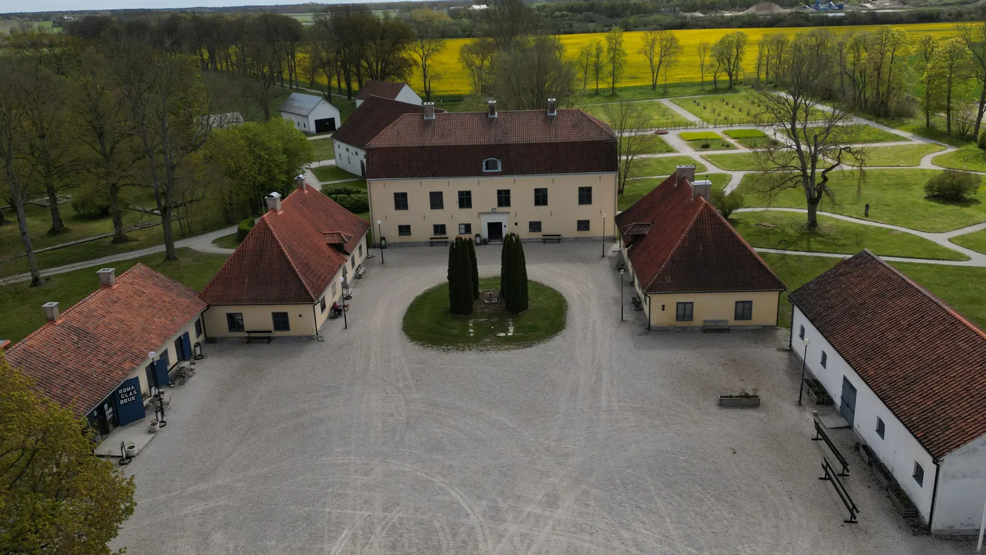 Flygbild av Roma kungsgårds huvudbyggnad och fyra flyglar. Tidig vår.