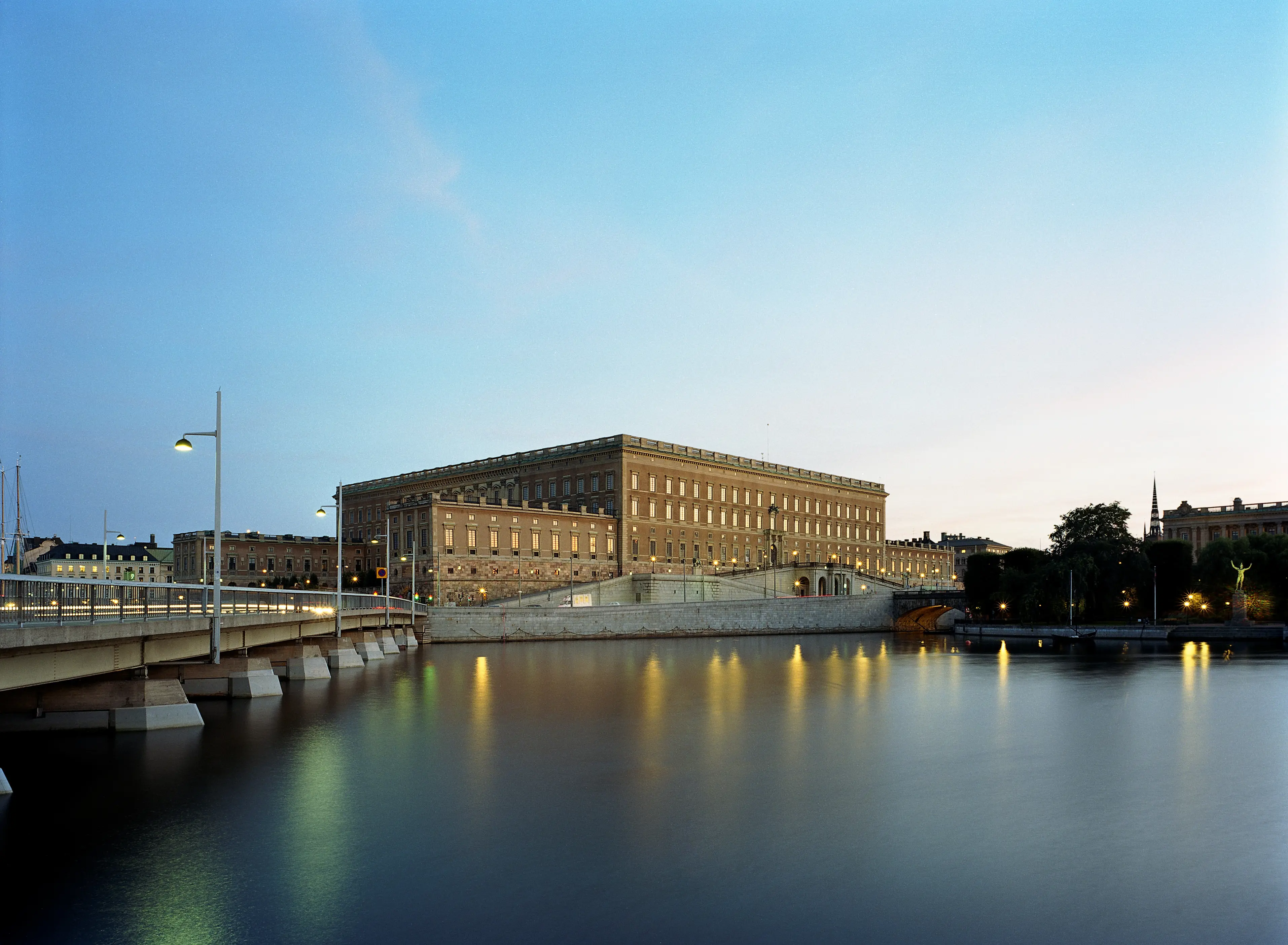 Stockholms slott sett över vattnet från Kungsträdgården. Skymning.