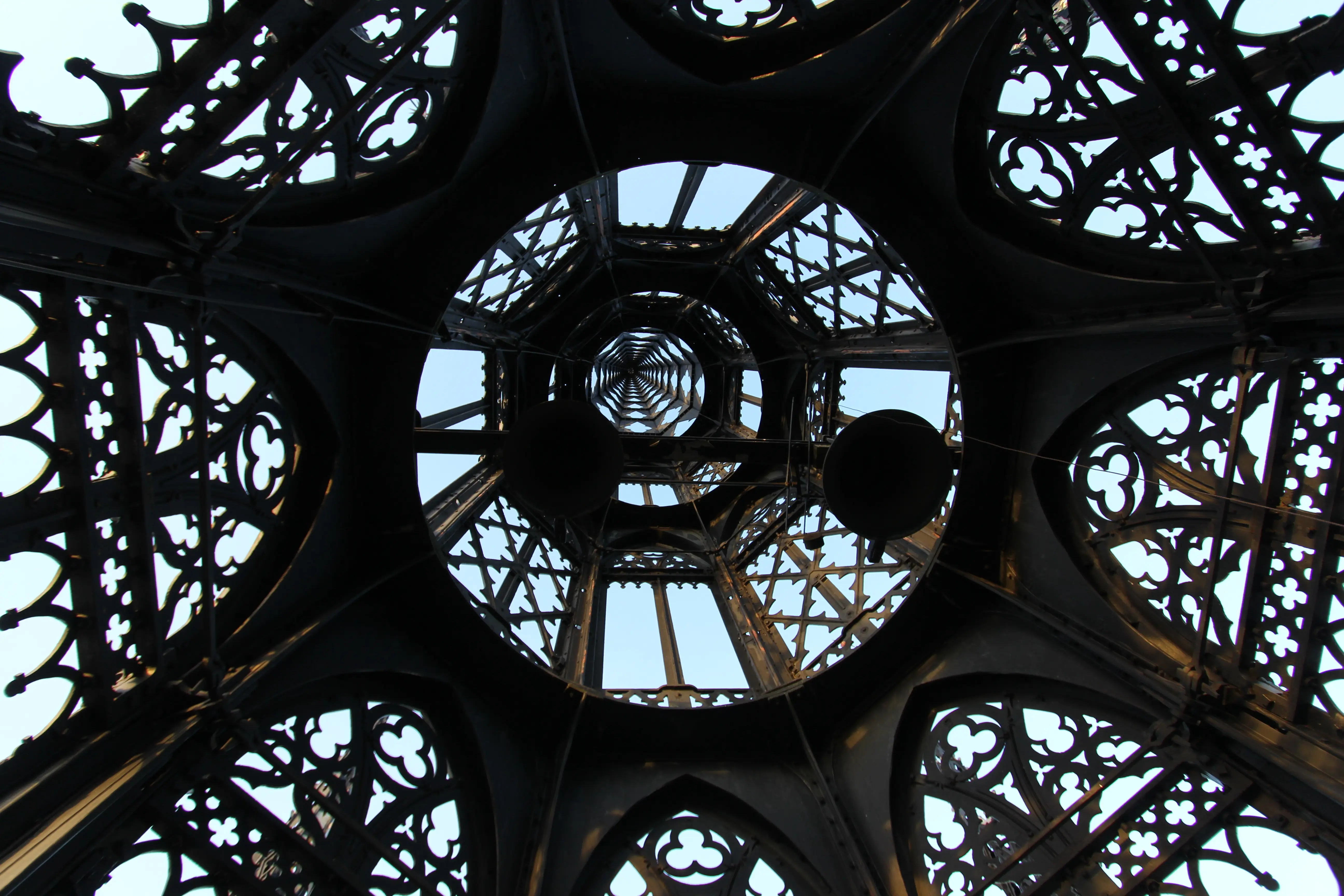 Riddarholmskyrkans spira fotograferad underifrån upp mot blå himmel