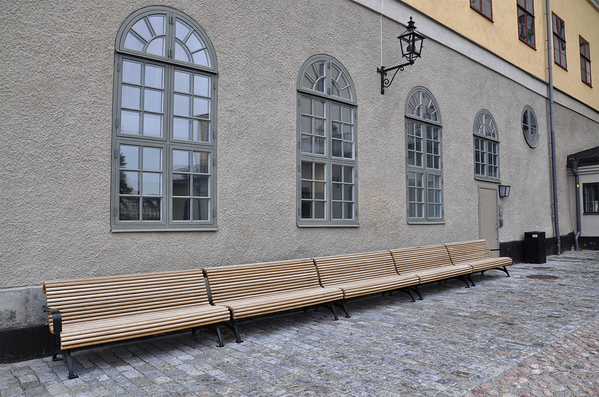 Bänkar gjorda av ek från Visingsö mot en husfasad på Riddarholmen.