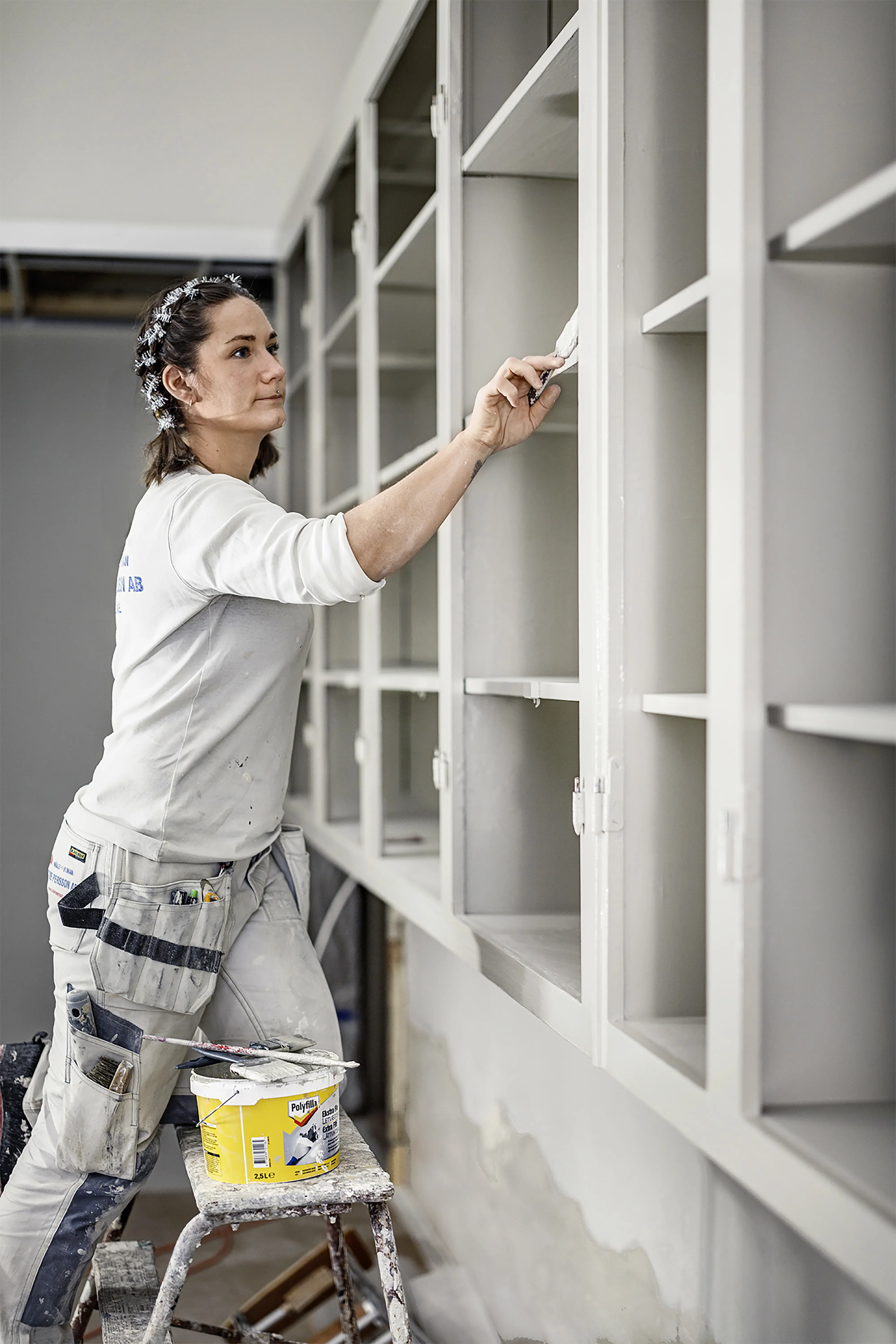 Målaren Sylvia Pekacka målar bokhyllor.