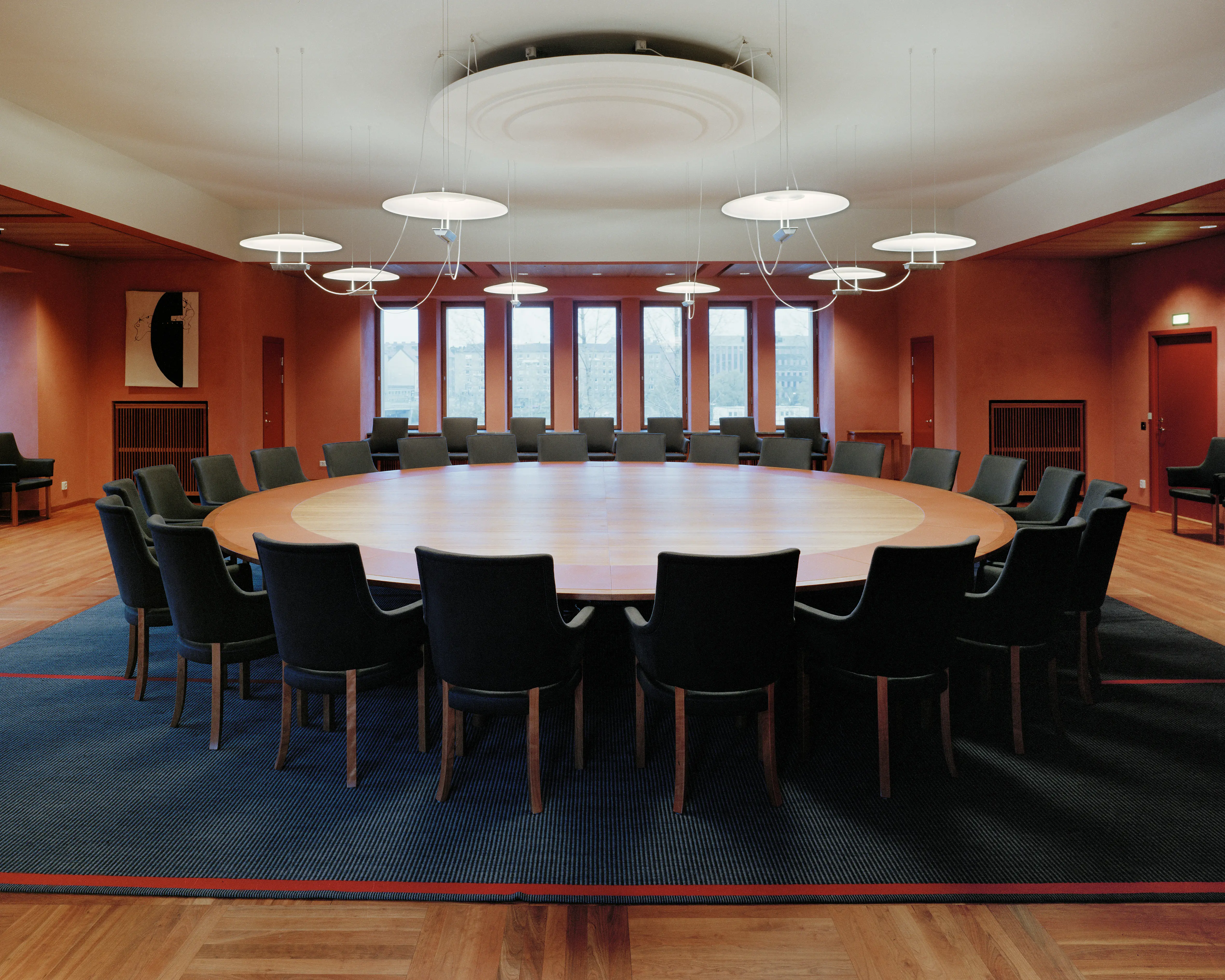 Interiör, Nobel Forum. Konferensrum med stort fönsterparti. Ett stort, runt bord står på en mörkblå matta. Väggarna är rödmålade.