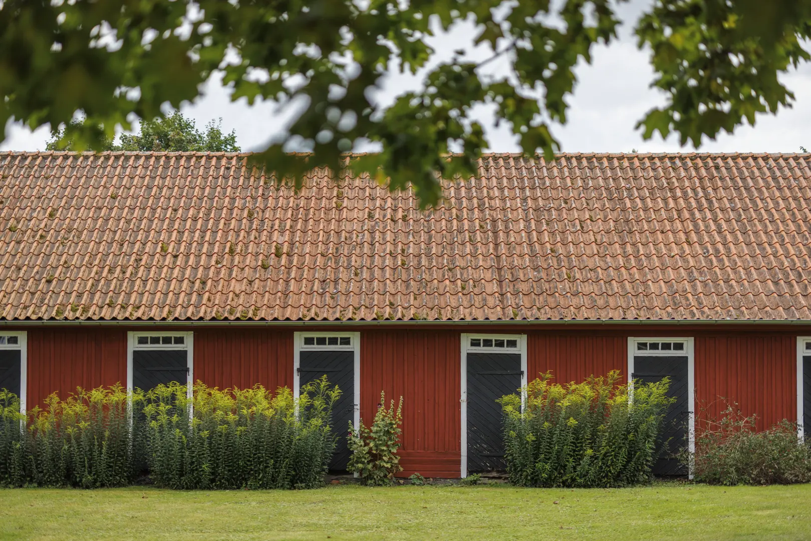 Rödmålat trähus med tegeltak.