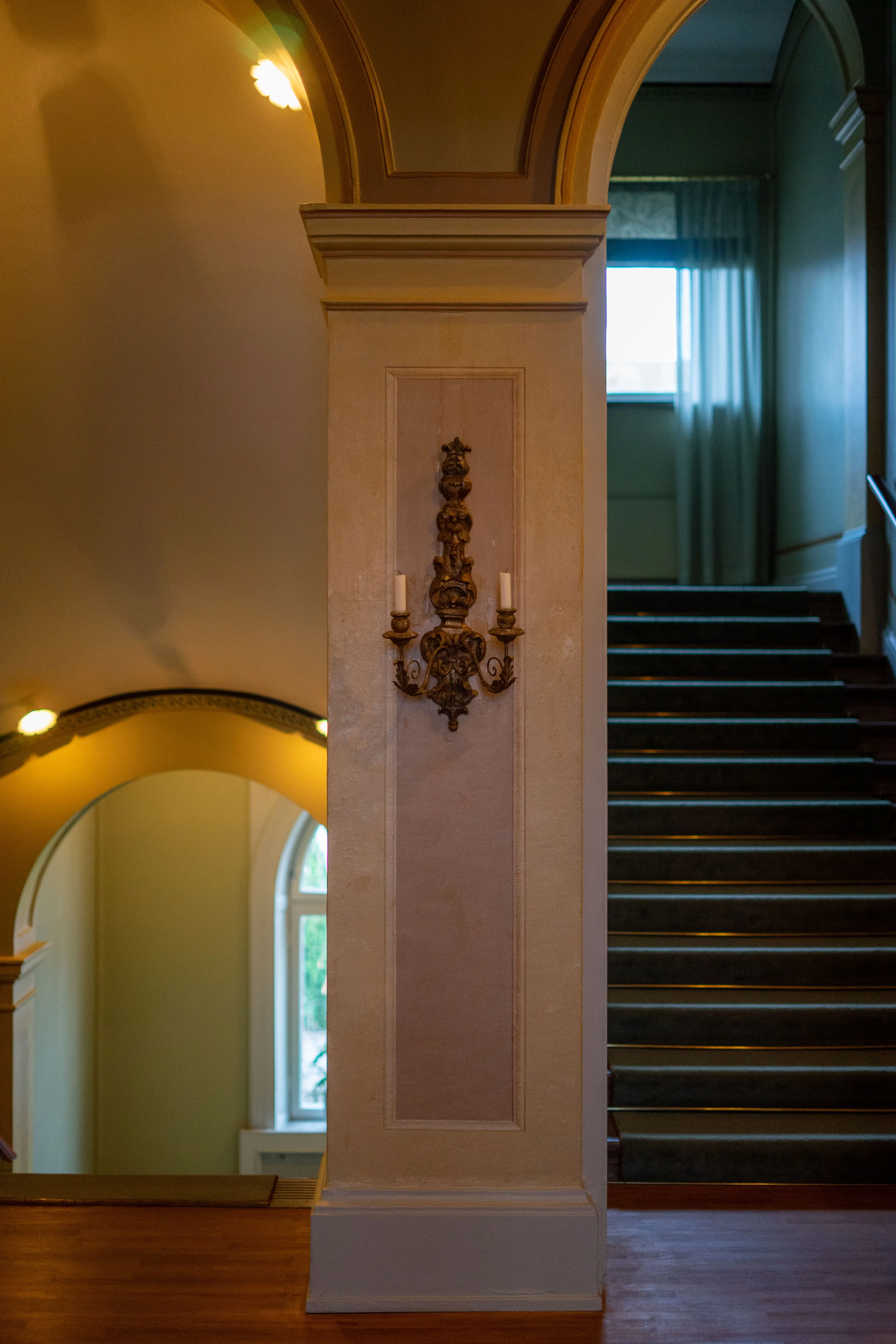 Residenset i Jönköping. Trapphall med rosa och gula väggfält. Trapporna har gröna mattor.