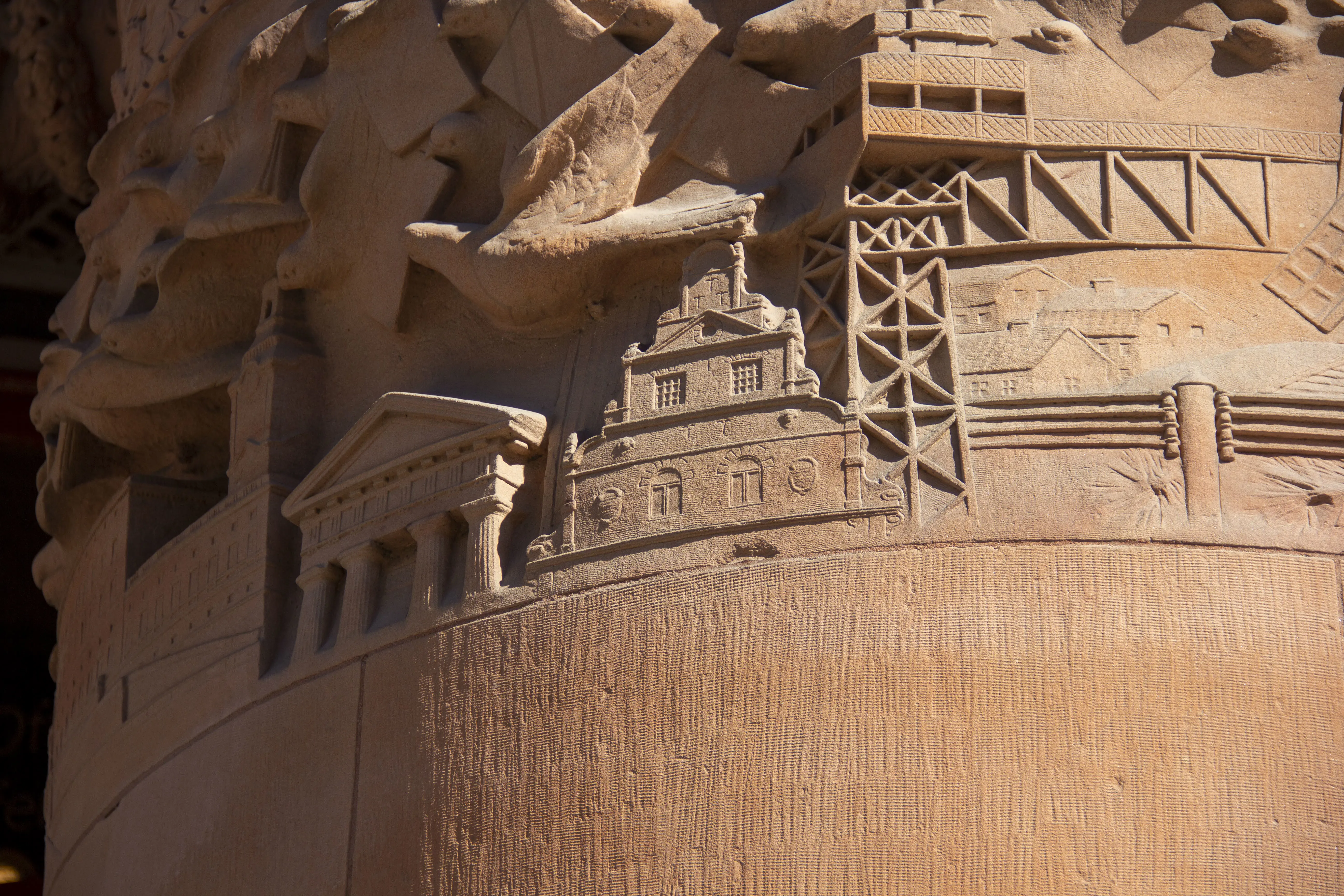 Centralposthuset, detalj av fasaden. Ljusröd stenrelief med brevduvor som flyger över välkända stockholms-byggnader.