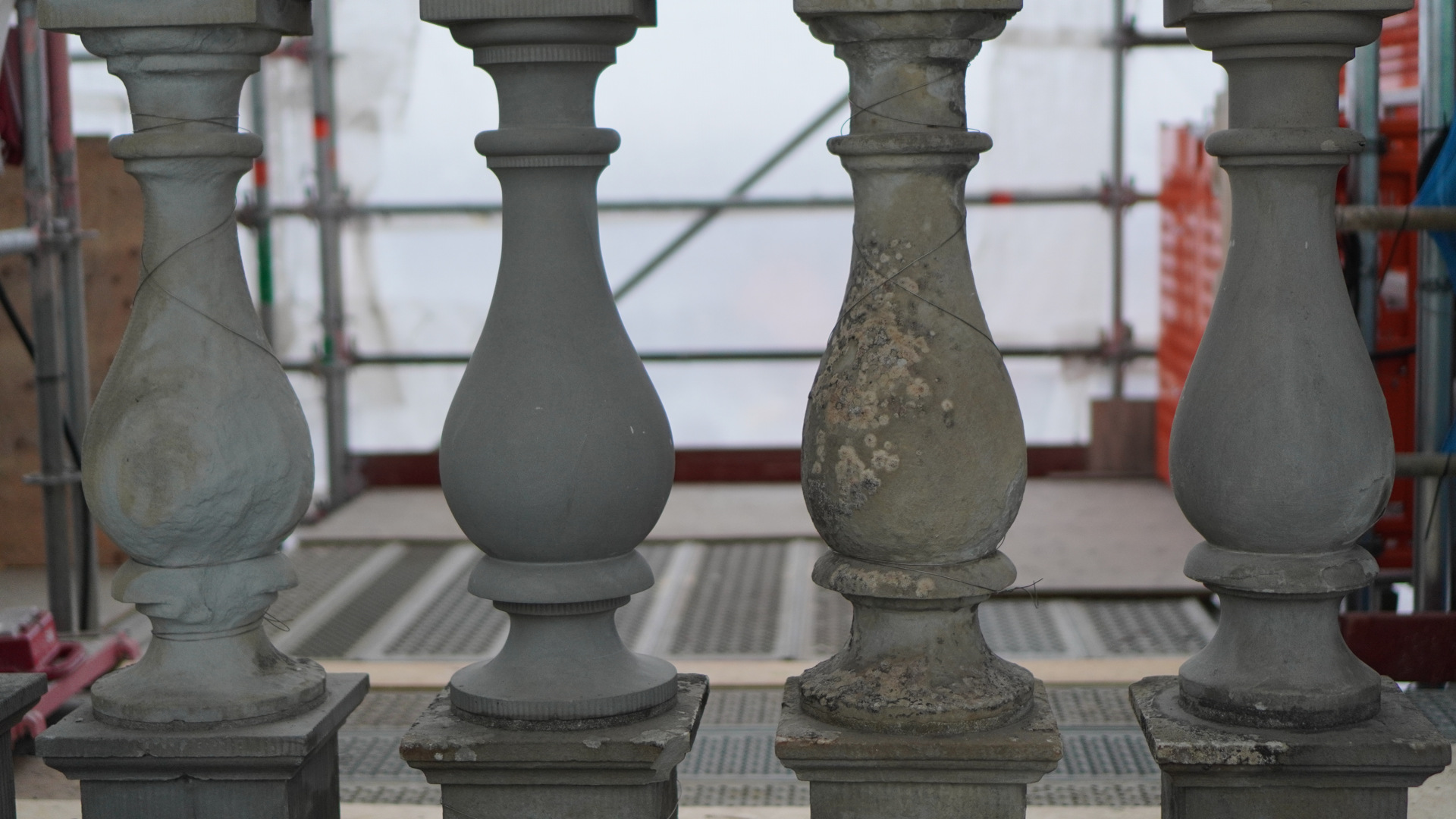 Stockholms slott. Fyra balustrad-dockor i sten. En av dem är helt ny, de andra är slitna och vittrade. En täckt med alger.