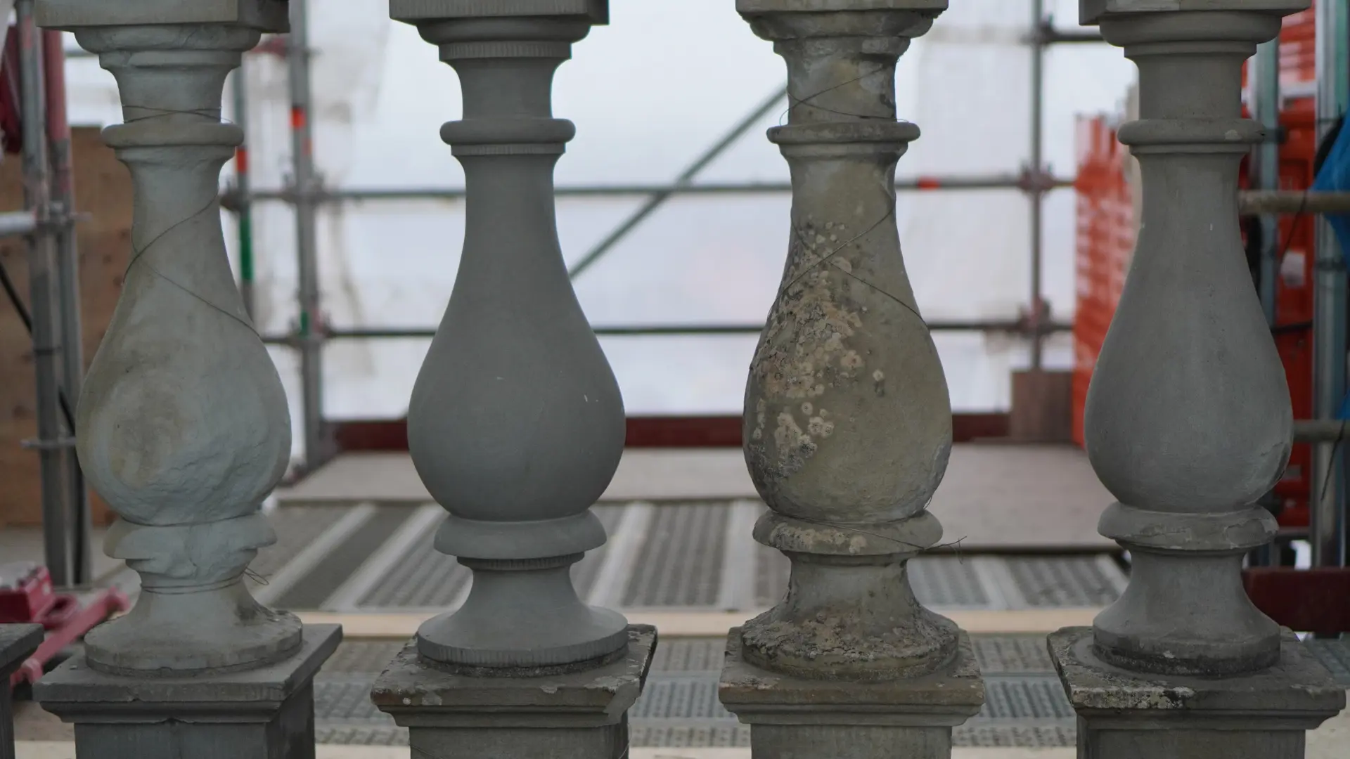 Stockholms slott. Fyra balustrad-dockor i sten. En av dem är helt ny, de andra är slitna och vittrade. En täckt med alger.