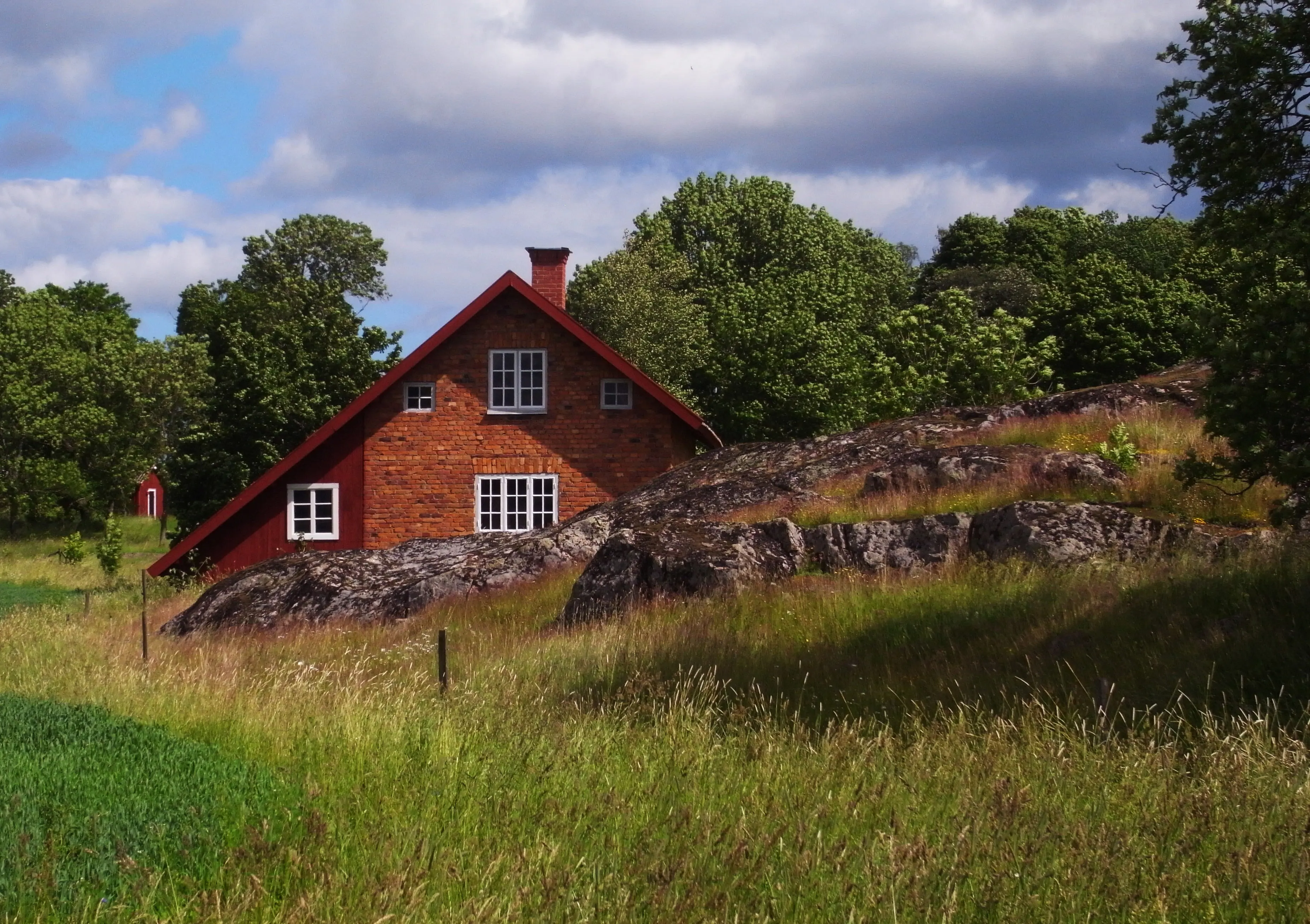 Landsberga gård. Smedja i tegel, belägen avsides från övrig bebyggelse. Sommar och grönska.