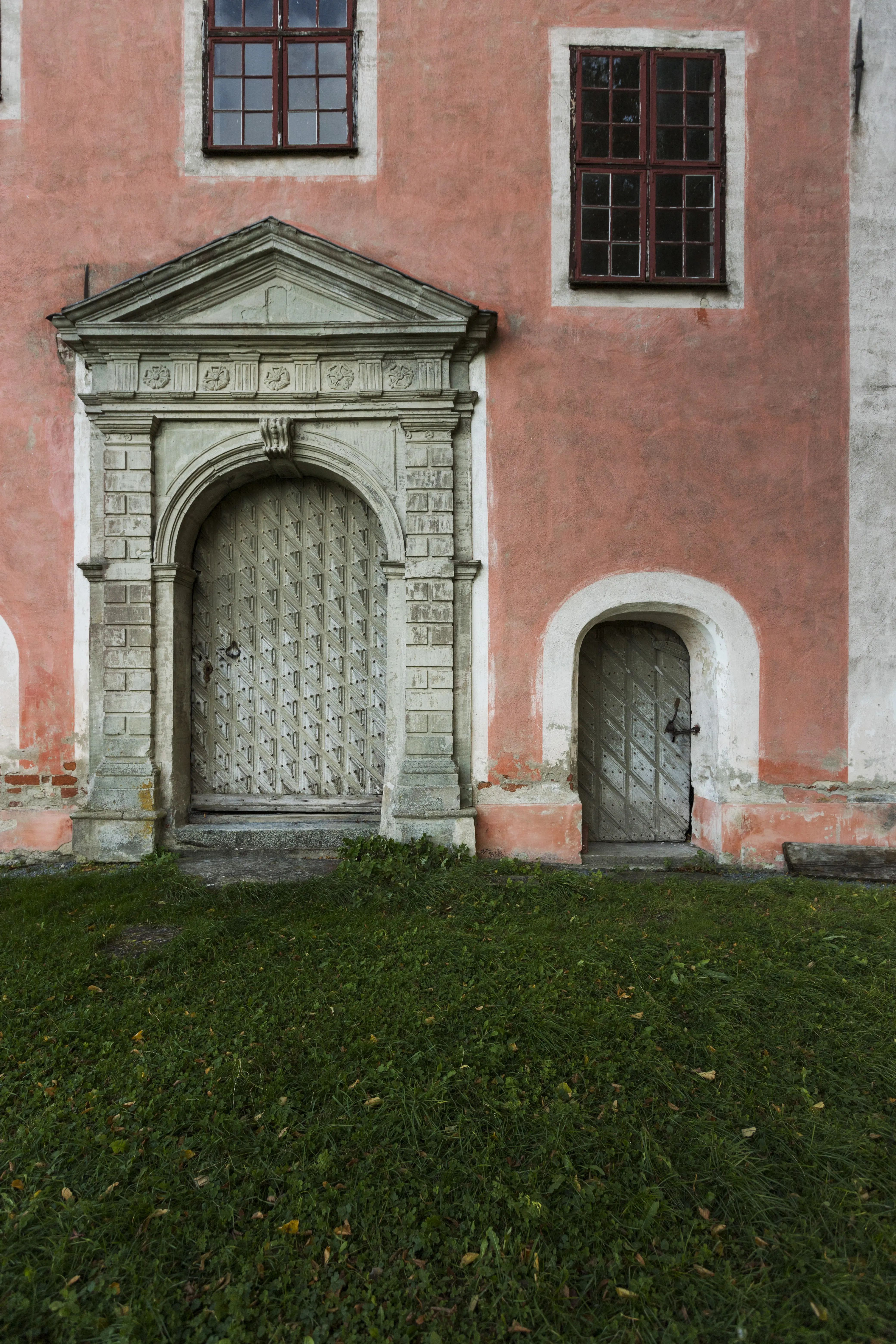 En stor och liten port in till Tynnelsö slott. Den större porten ramas in av en praktfull stenportal med klassicistiska drag.